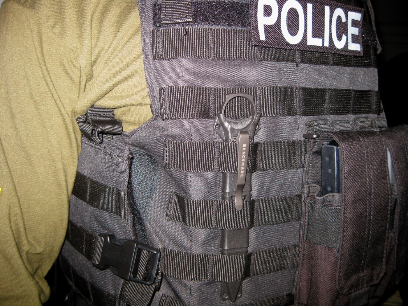 Here the sheath is threaded vertically through MOLLE webbing on a vest. You can see the sheath body’s ridges holding it tightly in place. The black steel clip presses down to keep everything stable during movement. It’s built to stay put even when you’re rolling around or engaging in CQC. The sheath’s design maximizes accessibility without giving up retention. This is what makes it different from just shoving a blade into a belt.