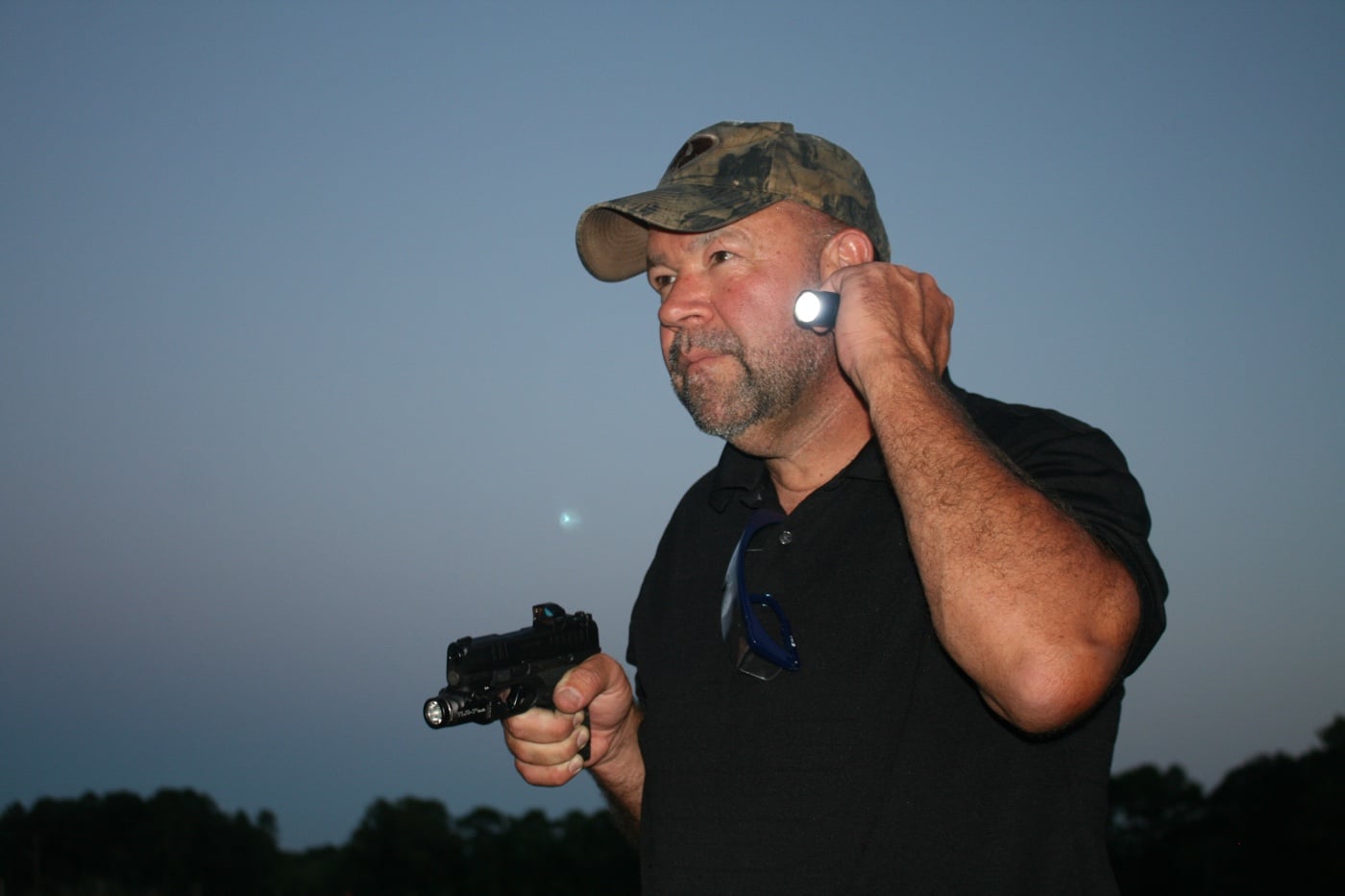 Photo of a Streamlight PROTAC 2L-X USB flashlight lying next to a Springfield Hellcat for size comparison. The flashlight is roughly the same length as the pistol’s slide, emphasizing how compact and pocket-friendly it is. Its tailcap switch and body clip are clearly visible, underscoring its EDC design. Although not a dedicated WML, it serves as a solid companion for those who carry micro-compact pistols. Using lights for micro-compact pistols doesn’t always mean mounting them — handhelds still play a vital role.