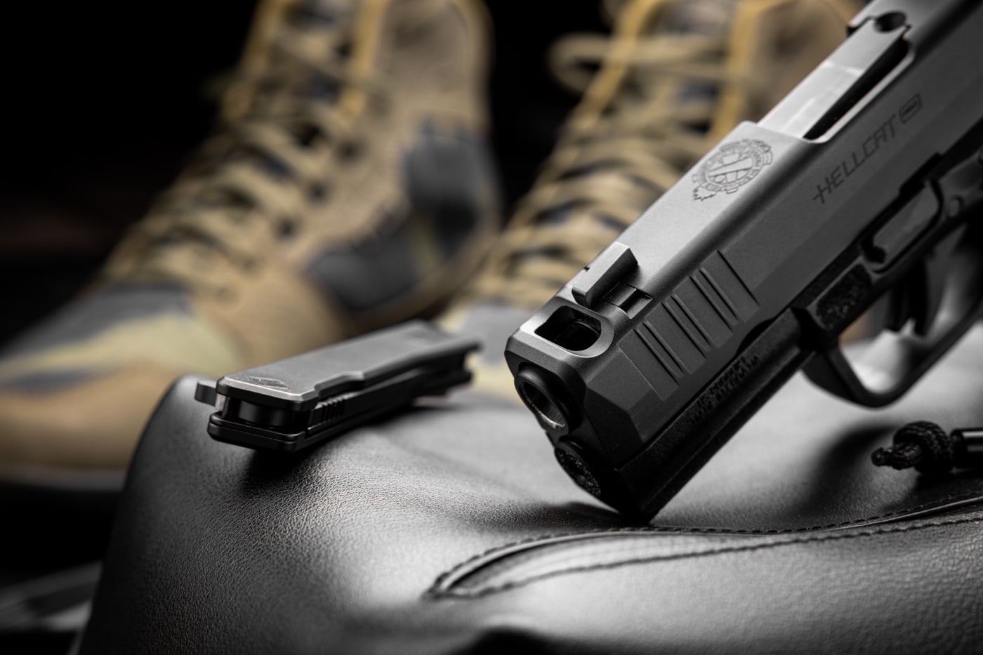 Side view of a shooter firing a ported handgun at an indoor range. Muzzle blast is visible at both the bore and the top port. The shooter maintains a proper stance and grip. The image shows how compensators work in real time. This photo supports the claim that comps help reduce recoil and aid fast follow-up shots.