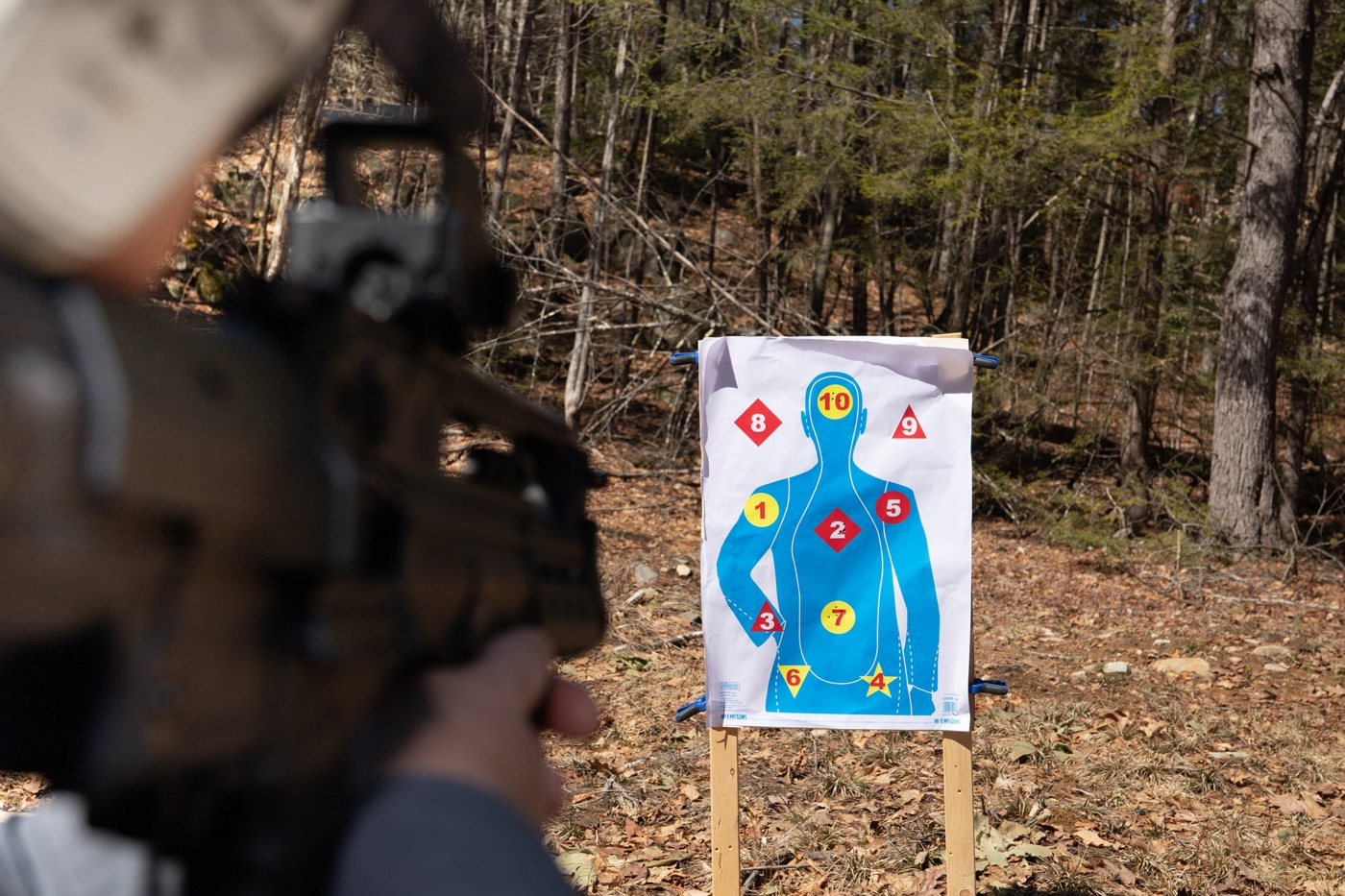 A shooter engaging targets while kneeling, using the Mepro Tru-Vision SR. Demonstrates fast transitions and positive target acquisition. No need to line up front and rear sights. The shooter can stay focused on the target. The red dot allows accurate fire from less stable positions.