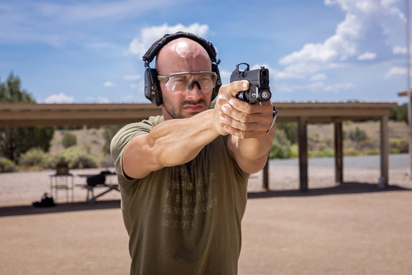 A side view of a micro pistol on a table with a weapon light mounted tightly under the barrel. The light doesn’t protrude significantly beyond the muzzle and follows the contour of the frame. This allows for smoother reholstering and less chance of snagging. The gun is unloaded and slide locked open, underscoring safe handling. Using lights for micro-compact pistols means thinking through small details like this to keep your carry rig functional and safe.