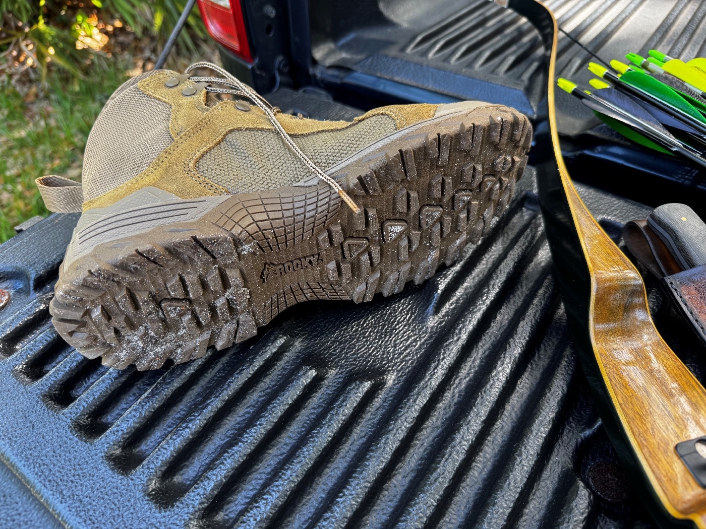 Detailed view of the Rocky Mountain Combat Boot’s composite outsole showing multi-directional lug configuration. The lug edges form angular, irregular shapes intended for solid traction in various terrains. Small flecks of dirt and grass are trapped within the treads, hinting at recent field use. The outsole material appears dense and oil-resistant, matching the Rocky Mountain Combat Boot Review notes about slip resistance. This close-up shot underlines the boot’s technical lug design for outdoors, tactical and military applications.