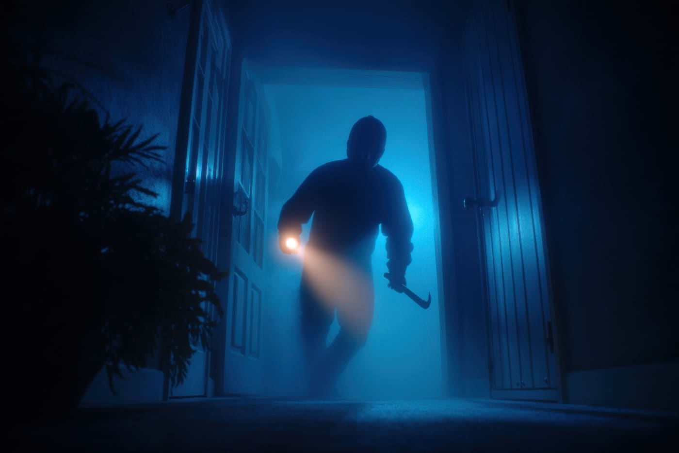 A man is seen breaking into a dark house, emphasizing a common scenario faced by many homeowners during home invasions. This image is relevant to learning how to survive a home invasion because it depicts forced entry, which is a standard tactic used by burglars and home intruders. The scene underlines weaknesses in residential security like insufficient lighting and vulnerable entryways. For those interested in home defense tactics, this type of intrusion stresses the need for reinforced doors, quality locks, and exterior lighting. Home invasions can happen quickly and unexpectedly, especially after dark, when visibility is poor. Understanding how criminals approach and breach homes is a crucial factor in preparing to survive a home invasion. Prevention, early warning, and response measures are key parts of any plan. This photo provides a visual context for discussions about burglary, forced entry, and personal safety in your own home.