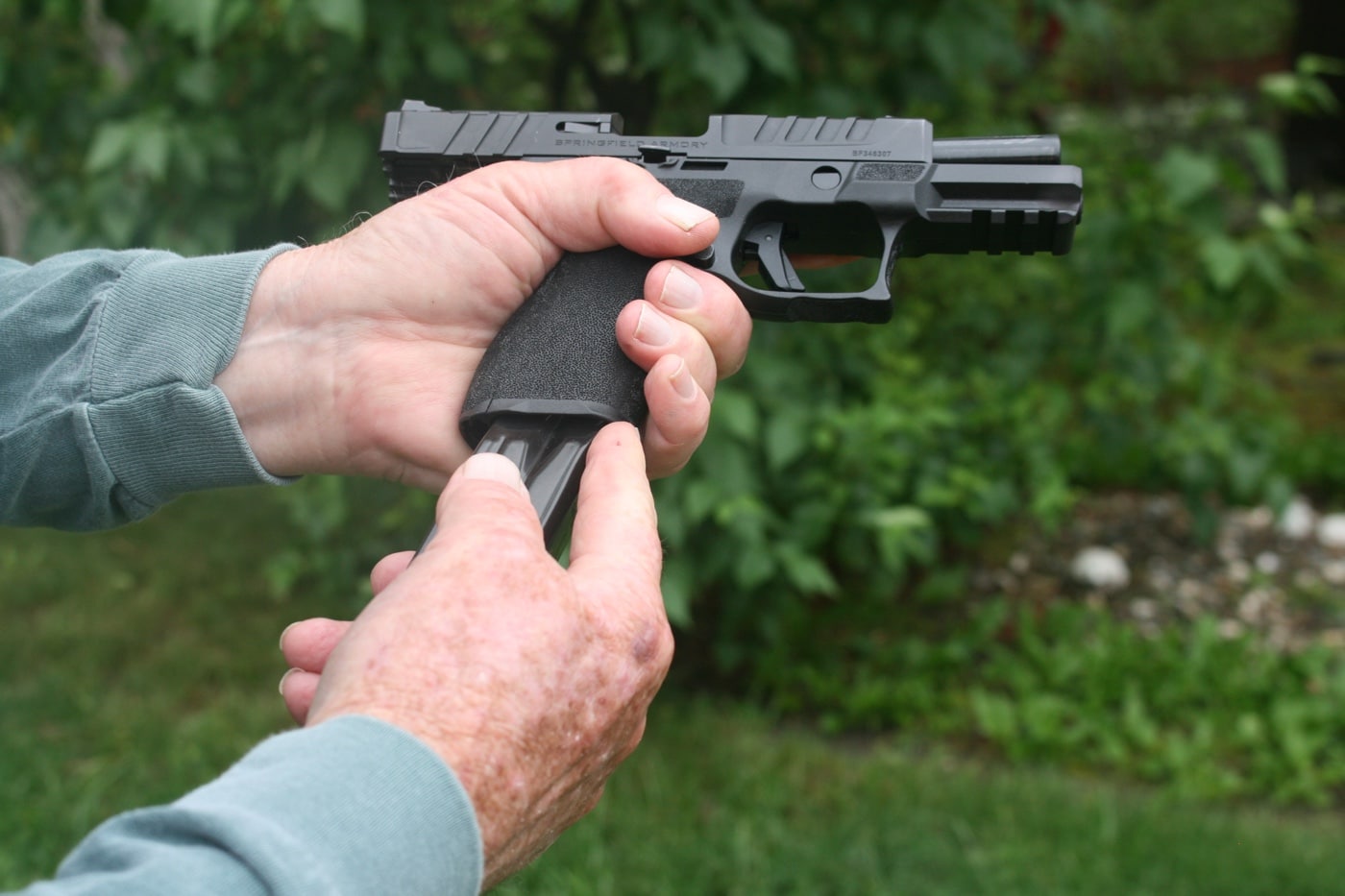 using index finger to guide magazine into pistol