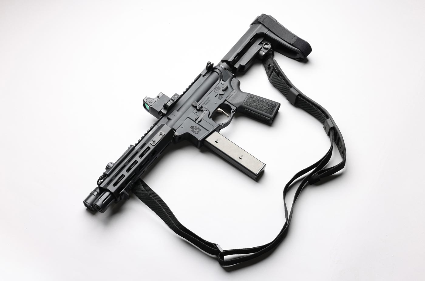 The Springfield Armory SAINT Victor 8.5” pistol chambered in 9mm is pictured lying flat on its side with a two-point sling attached. The sling connects at the rear of the SBA3 brace and near the front of the handguard, allowing for stable carry and easy transitions. This AR-style pistol setup keeps things compact while adding functional control for carry or retention. The gun’s lightweight build and short barrel make it well-suited to sling use, especially in close quarters or confined spaces. This photo supports the SAINT Victor 8.5” 9mm Pistol review’s discussion on practical accessories and real-world application.