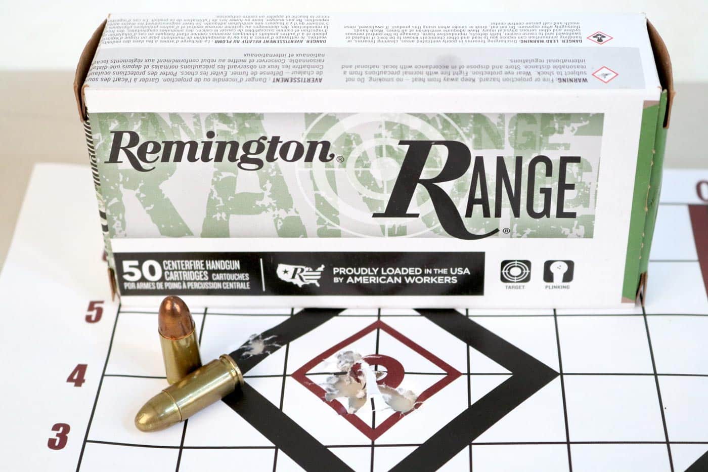 Remington 9mm range ammunition is shown alongside a used paper target featuring multiple tight shot groups. The ammo appears to be full metal jacket rounds commonly used for practice or informal training. The target was part of the author’s testing during the SAINT Victor 8.5” 9mm Pistol review and reflects consistent accuracy. Despite being inexpensive range-grade ammo, the groups are tight and well-centered. This image illustrates that the pistol delivers excellent results even with basic, widely available 9mm loads.