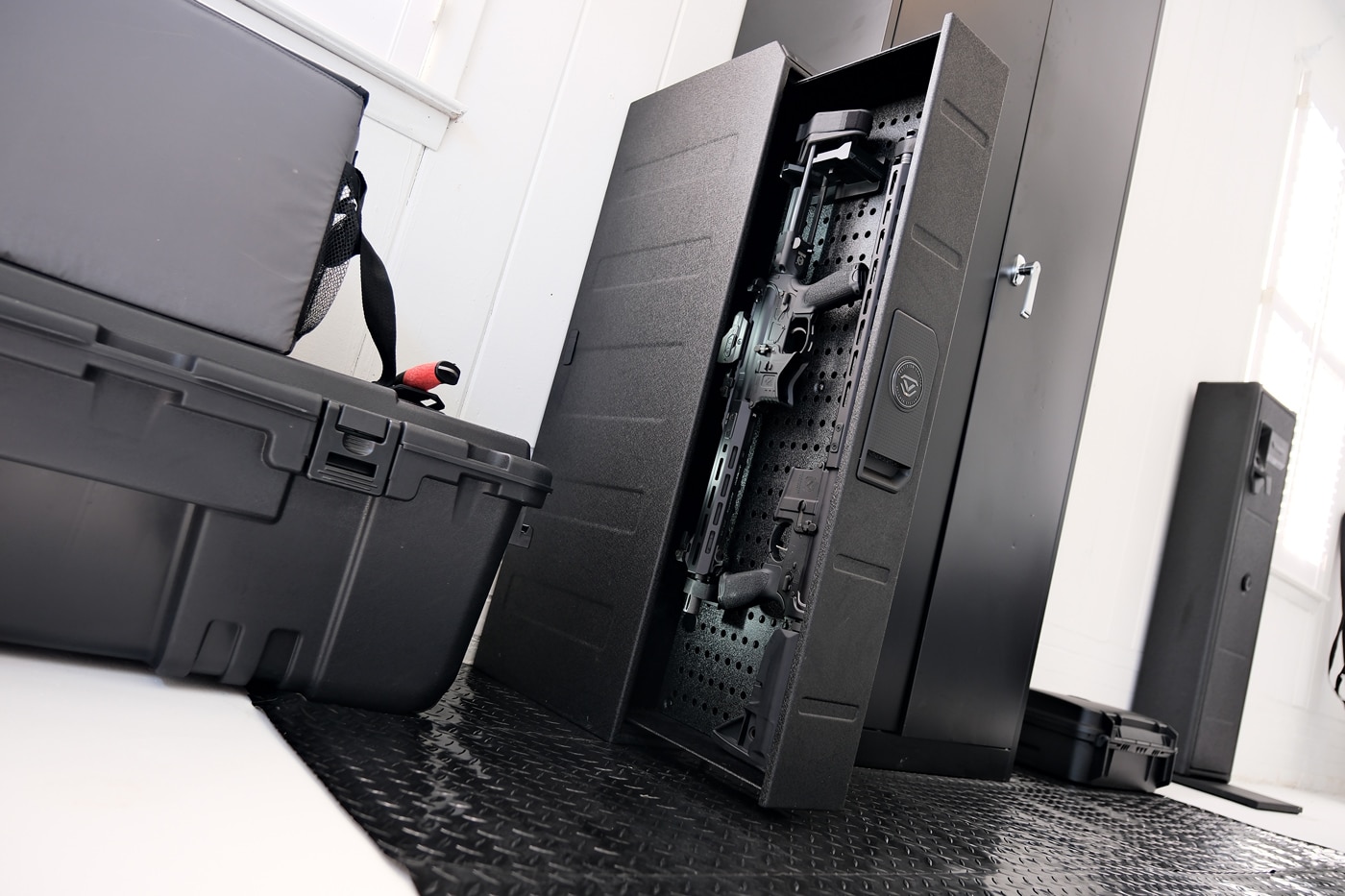 This image shows a Vaultek RS Slider Safe mounted in a vertical orientation inside a home workshop. The safe is installed against the wall near a workbench, surrounded by various woodworking and tool storage units. The vertical configuration has the drawer extending outward, providing clear access without taking up much floor space. The safe’s steel construction and electronic keypad are visible on the front panel. Nearby pegboards and tools reinforce the setting as a hobby or work area. This setup demonstrates how the RS Slider can be adapted for placement in unconventional locations outside the bedroom or closet. It's suited for people interested in versatile gun safe solutions for personal workshops or garages.