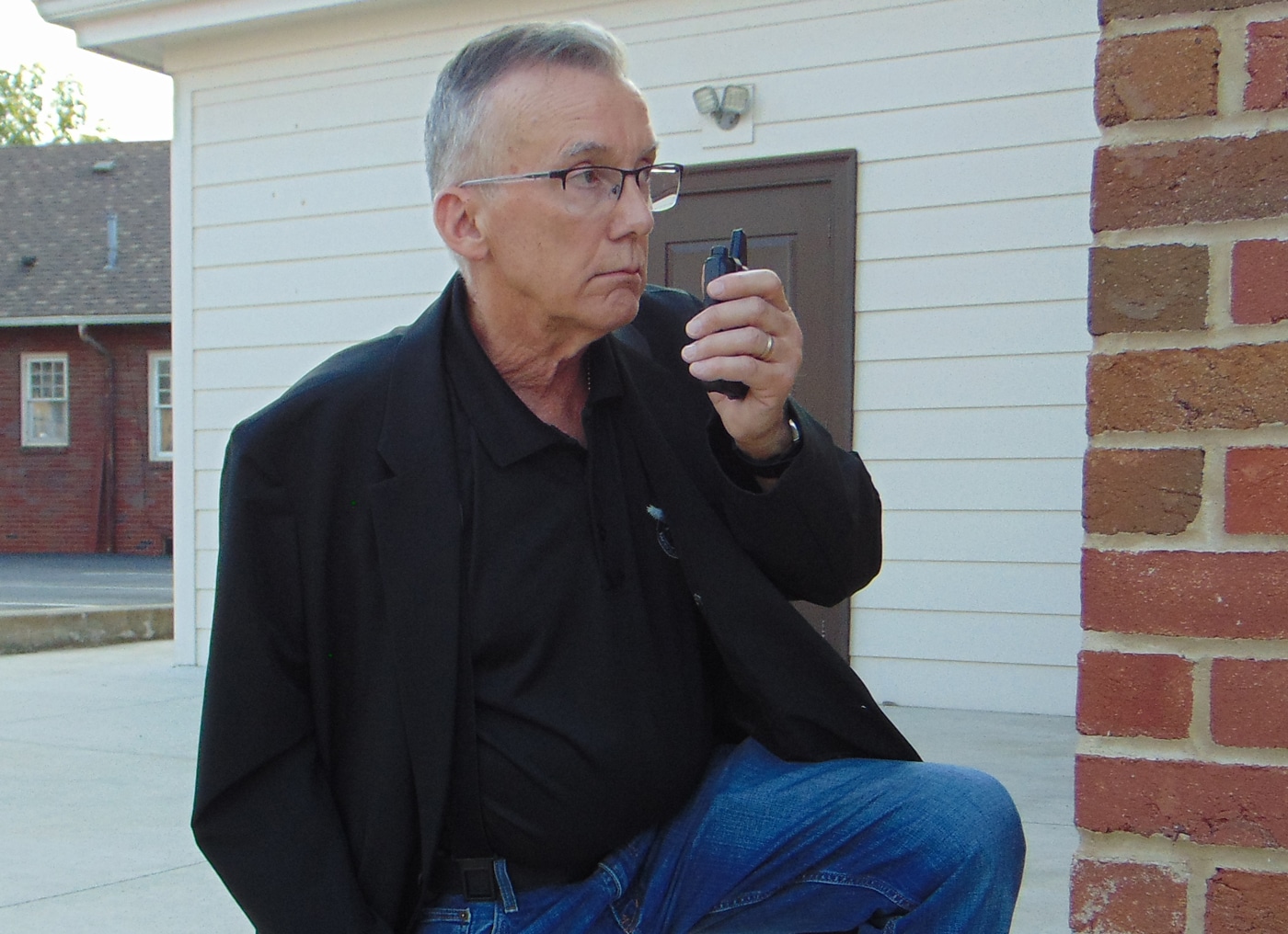 The close-up image captures the author kneeling while wearing the 5.11 Founder’s Jacket, with the camera focused on the jacket’s torso and upper legs. The fabric and cut are clearly visible, showing how the jacket maintains its tailored, dress-casual appearance even in a crouched or active stance. No bulges or outlines of concealed gear are visible, illustrating the effectiveness of the jacket’s internal pocket and support systems for keeping firearms or other equipment discreet. The lighting and composition highlight the smooth material and subtle details, such as the seams and button closure. The shot emphasizes the jacket’s comfort and practical fit during movement, making it ideal for concealed carry and security work. This photo supports the 5.11 Founder’s Jacket review by showing how the jacket performs in real-life scenarios.