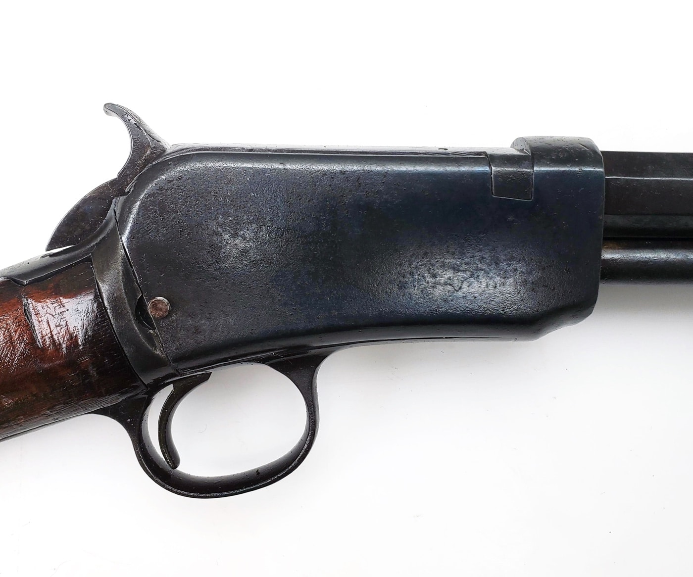 This image shows a close-up of a rifle receiver that has just been treated with a cold blue finish after rust was removed. The metal surface now appears smooth and dark, with an even color that indicates a protective coating has been applied. Any previous signs of orange or brown rust are gone, replaced by the deep blue-black tint typical of cold bluing solutions. The finish not only improves the look of the receiver but also helps shield it from future corrosion. The background is plain, focusing attention on the newly restored metal. This stage comes after cleaning and prepping the receiver, showing what gun owners can expect when they use a cold blue product on their firearm parts. The result is a receiver that looks close to new and is better protected from moisture and handling.