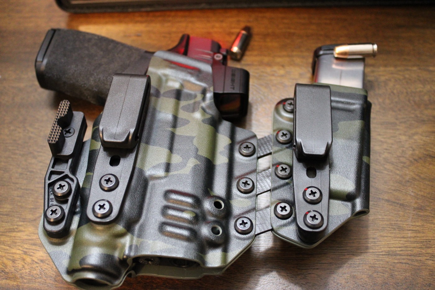 A Springfield Hellcat Pro pistol with a Streamlight TLR 7 Sub weapon light attached is shown secured inside a Black Arch Entrada holster. The holster features a claw and wedge for added concealment and a robust clip for firm attachment to a belt. The photo highlights the precise fit of the holster around the firearm and light, demonstrating compatibility with mounted accessories. The combination ensures the pistol is held securely and positioned for a smooth draw, even with additional gear attached. This image underscores the value of selecting a holster specifically designed for both your handgun and any lights or optics you carry.