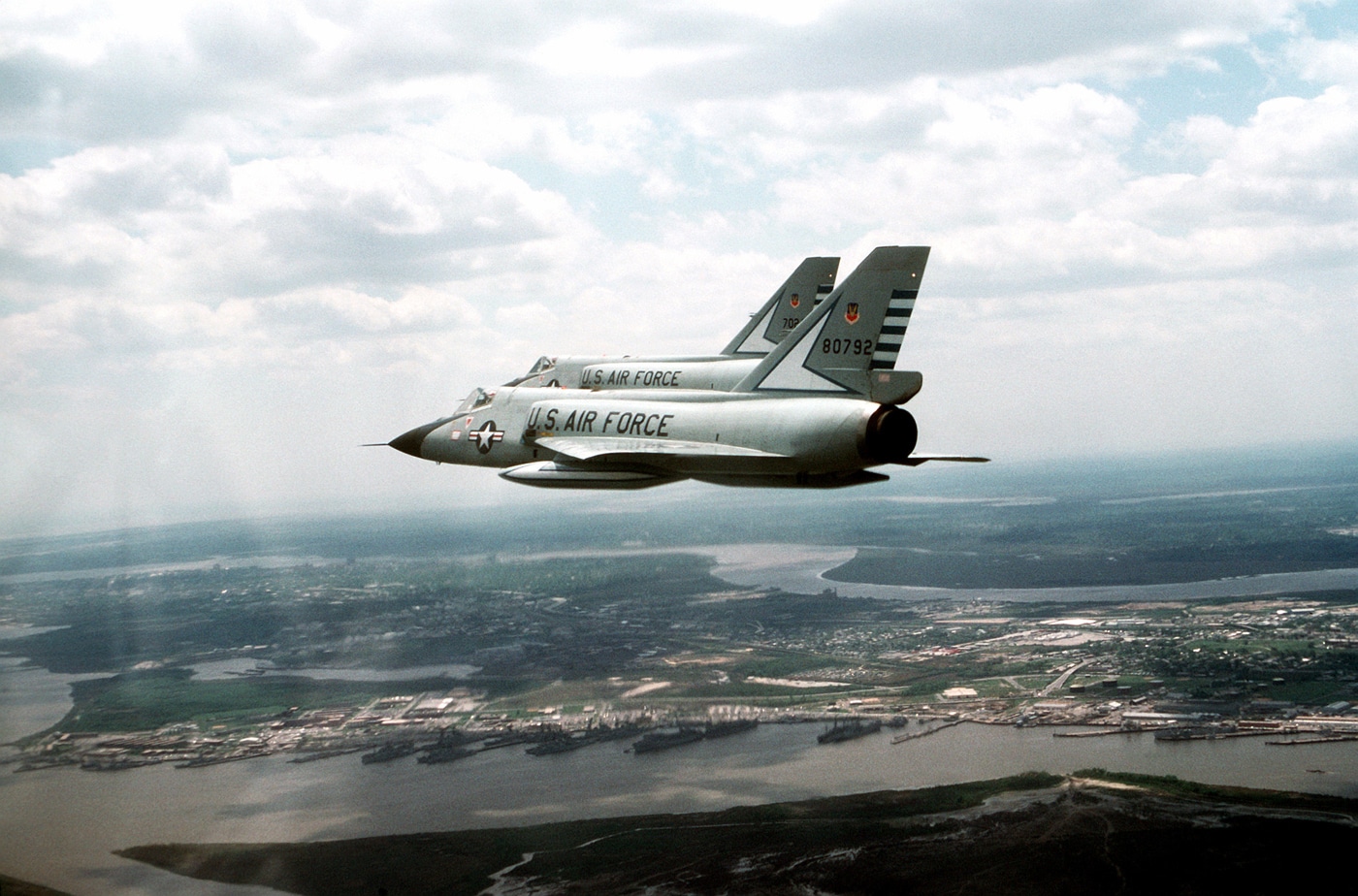 two Convair F-106 Delta Dart interceptors fly over Charleston Naval Base