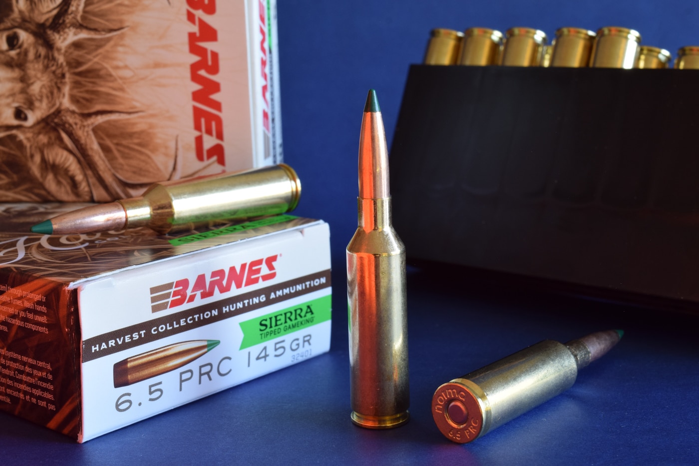Close-up photograph of the 145-grain Sierra Tipped GameKing bullet seated in a 6.5 PRC cartridge from Barnes’s Harvest Collection. The round features a bright brass case, copper jacket, and a colored polymer tip for improved aerodynamics. The bullet’s long, tapered profile is designed for high ballistic coefficients, aiding in long-range hunting accuracy. This is the newest TGK variant to join the Harvest Collection line, aimed at deer-sized game. The image focuses on the cartridge’s clean manufacturing and streamlined bullet design. Background is neutral to keep emphasis on the ammunition.
