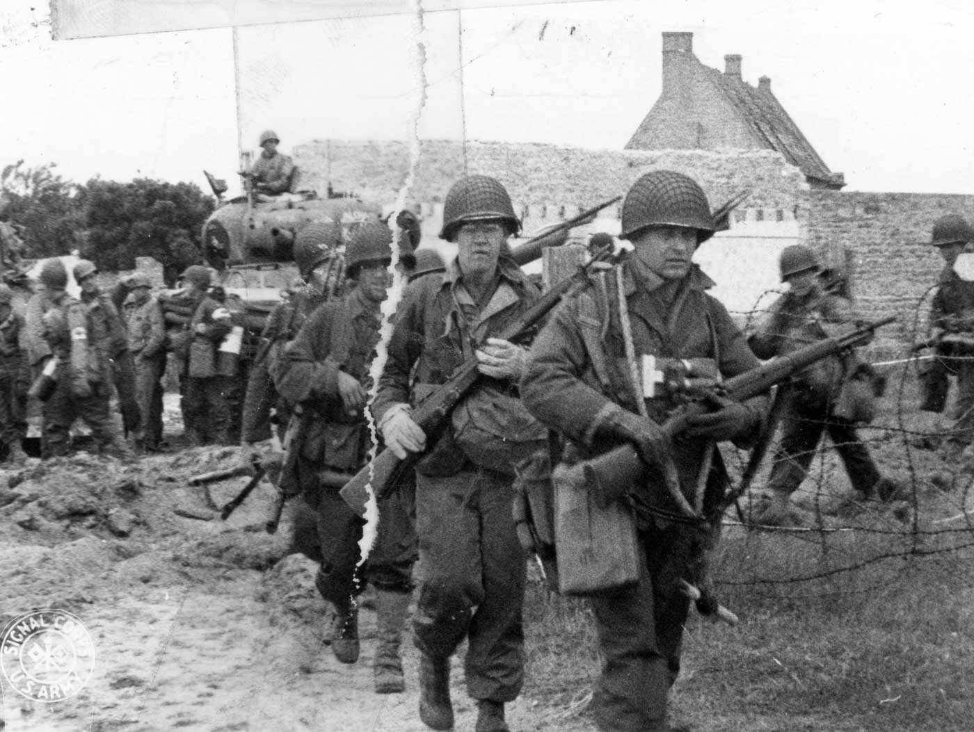 American troops move through a French village in Normandy on June 9 1944