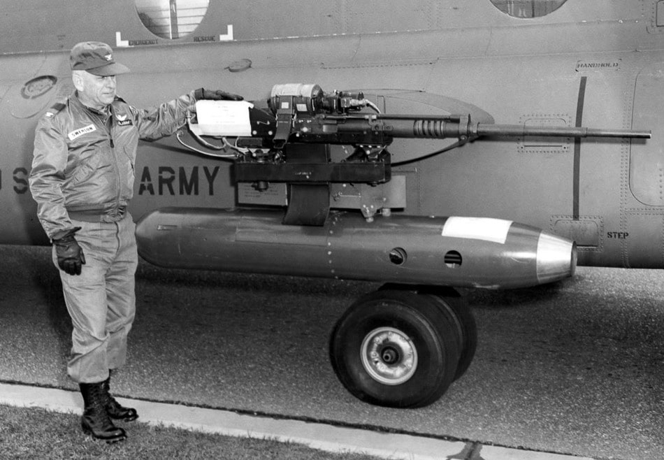 The image shows the right pylon of an ACH-47A Chinook gunship where the standard 2.75-inch rocket launcher has been replaced with an M18E1 gun pod. This pod houses an M134 Minigun, a six-barrel rotary machine gun chambered in 7.62×51mm NATO. The M134 is capable of firing between 2,000 and 4,000 rounds per minute, making it ideal for continuous suppressive fire. Mounted in place of the rocket pod, the M18E1 allowed crews to tailor the helicopter’s armament for specific missions. The gun pod is attached to a sponson-mounted weapons pylon along the aircraft’s side. The ACH-47A carried multiple weapon systems simultaneously, and this Minigun configuration offered precise, sustained fire over longer engagements. The photograph clearly displays the pod’s cylindrical shape, barrel cluster, and mounting hardware.