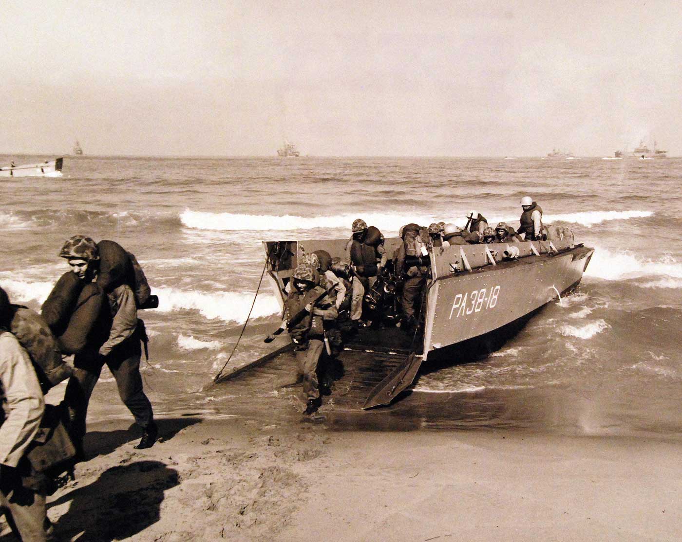 Marines unload from LCVP armed with bazookas and rifles