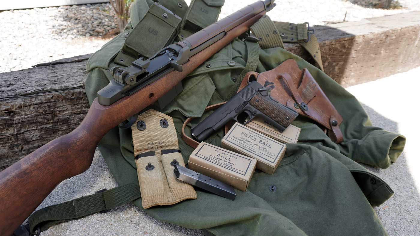 This image displays the Springfield Armory M1A rifle alongside the Springfield Armory Mil-Spec 1911 handgun. The two firearms are laid out together, showing the contrast between the larger walnut-stocked semi-automatic rifle and the parkerized steel .45 ACP pistol. The M1A features a traditional wooden stock and parkerized metal components, while the Mil-Spec 1911 shows off its checkered grips and classic military styling. Both guns are well-lit and clearly visible, emphasizing their condition and construction. The background is neutral and unobtrusive, keeping the focus on the firearms. This photo would be suitable for any article discussing the Springfield M1A and M1911 Mil-Spec, U.S. military-inspired firearms, or classic American service weapons. These Springfield Armory models are modern, accessible alternatives for collectors and shooters interested in American military history.