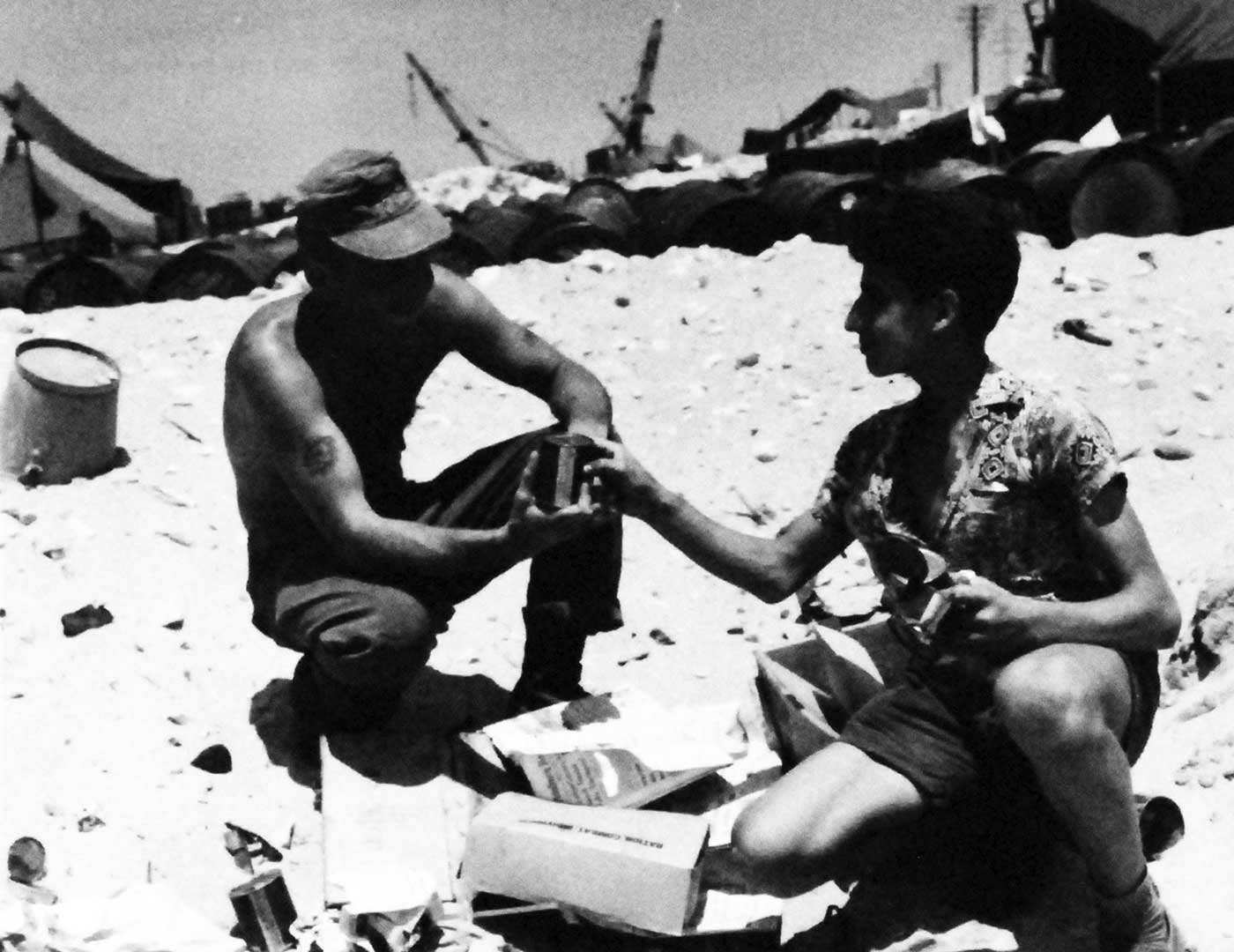 USMC Pfc Albert Knox shares a ration with a citizen of Lebanon