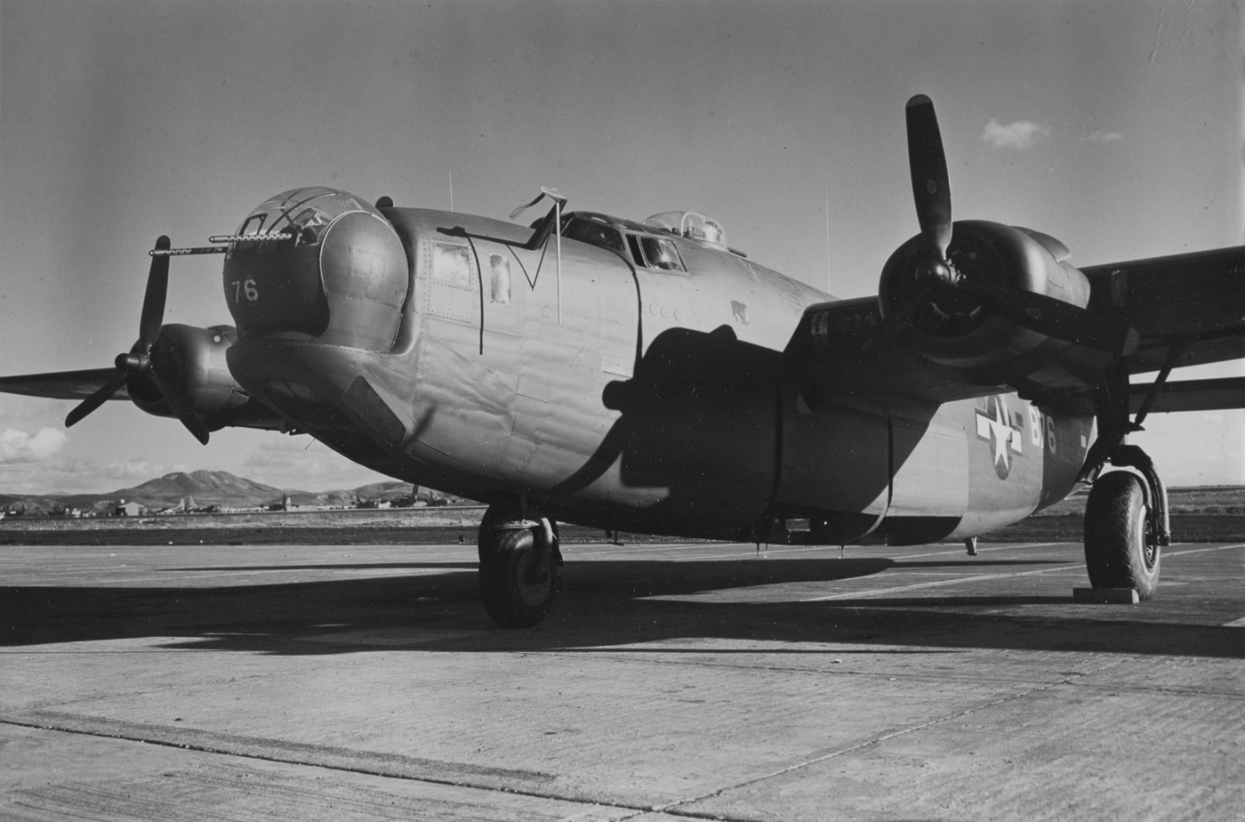 A Consolidated B-24 Liberator is photographed on the ground at Naval Auxiliary Air Station (NAAS) Kearney in California on December 27, 1944. The aircraft sits parked on the tarmac, with its twin tail and long Davis wing clearly visible. This wartime air station was used for training, modifications, and ferry operations as new bombers rolled off production lines. By this stage of the war, thousands of B-24s had passed through such facilities before being assigned to combat units overseas. The photo reflects the logistical backbone of U.S. air operations, showing how aircraft were staged, tested, and prepared before deployment. It underscores the scale of support required to maintain the Liberator fleet. The image is a rare look at a quiet stateside moment in the life of a bomber that otherwise saw action around the world.