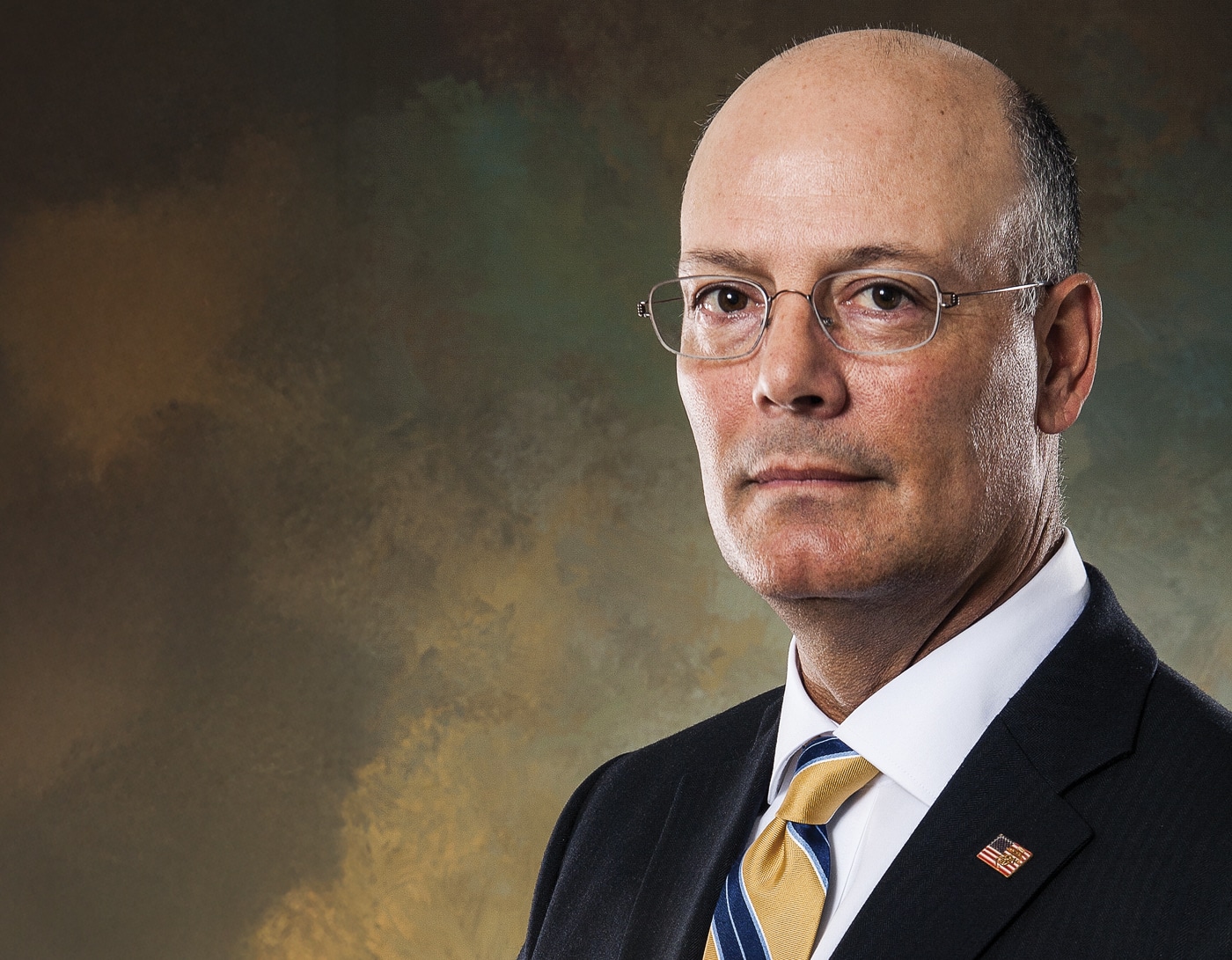 A professional publicity photo of Doug Hamlin, Chief Executive Officer and Executive Vice President of the NRA. He is shown in business attire, looking directly into the camera with a confident but approachable expression. The background is simple and uncluttered, designed to keep focus on him as the subject. The image conveys authority and professionalism, qualities associated with his leadership role. This type of portrait is commonly used for press releases, interviews, and organizational announcements. The composition emphasizes Hamlin’s role as the public face of the National Rifle Association.