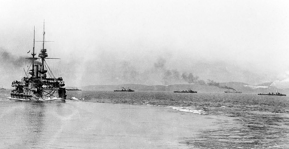 The photograph shows HMS Majestic, a British pre-dreadnought battleship, leaving Mudros harbor during the Gallipoli campaign in 1915. She has a broad armored hull, multiple heavy gun turrets, and tall funnels, typical of pre-dreadnought warship design. The Dardanelles Campaign saw several Allied battleships deployed in an attempt to force the straits and support landings against the Ottoman Empire. Majestic was among the warships tasked with bombardments and escort duties. However, the campaign highlighted the dangers of using battleships in confined waters filled with mines, shore batteries, and submarines. HMS Majestic was torpedoed and sunk by a German U-boat later in May 1915, with significant loss of life. The photo captures her at Mudros before her final mission, symbolizing the risks and failures of battleship operations during the campaign.