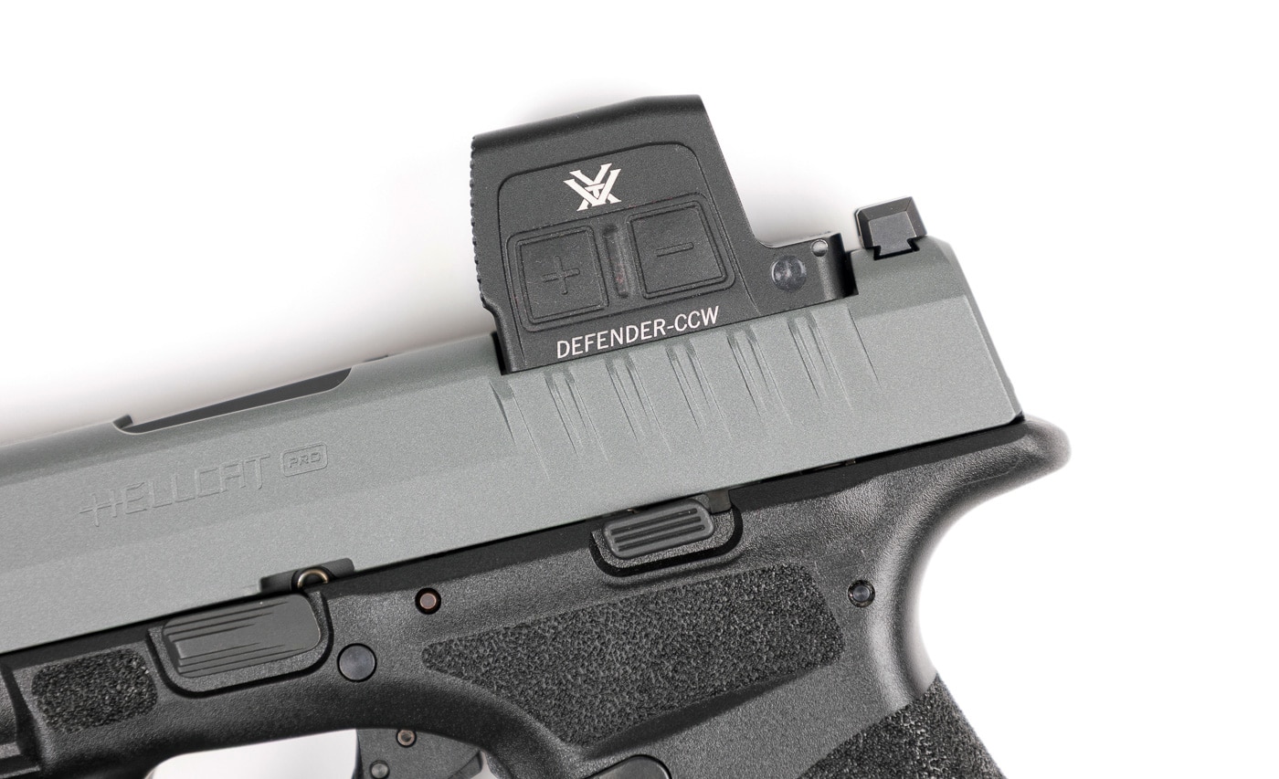 Side view of a Springfield Armory Hellcat Pro handgun with a Vortex Defender-CCW Enclosed red dot sight installed. The optic is mounted directly to the slide using the Shield RMS footprint, eliminating the need for an adapter plate. The compact CCW model is designed to keep weight and bulk to a minimum, making it well-suited for concealed carry. Its 7075 aluminum housing features Fast-Rack texturing at the front for slide manipulations, while the aspherical lens provides a clear, distortion-free sight picture. The optic’s solar panel and side-loading battery are visible, emphasizing its dual-power system. The pistol’s slim profile remains intact, even with the red dot attached.