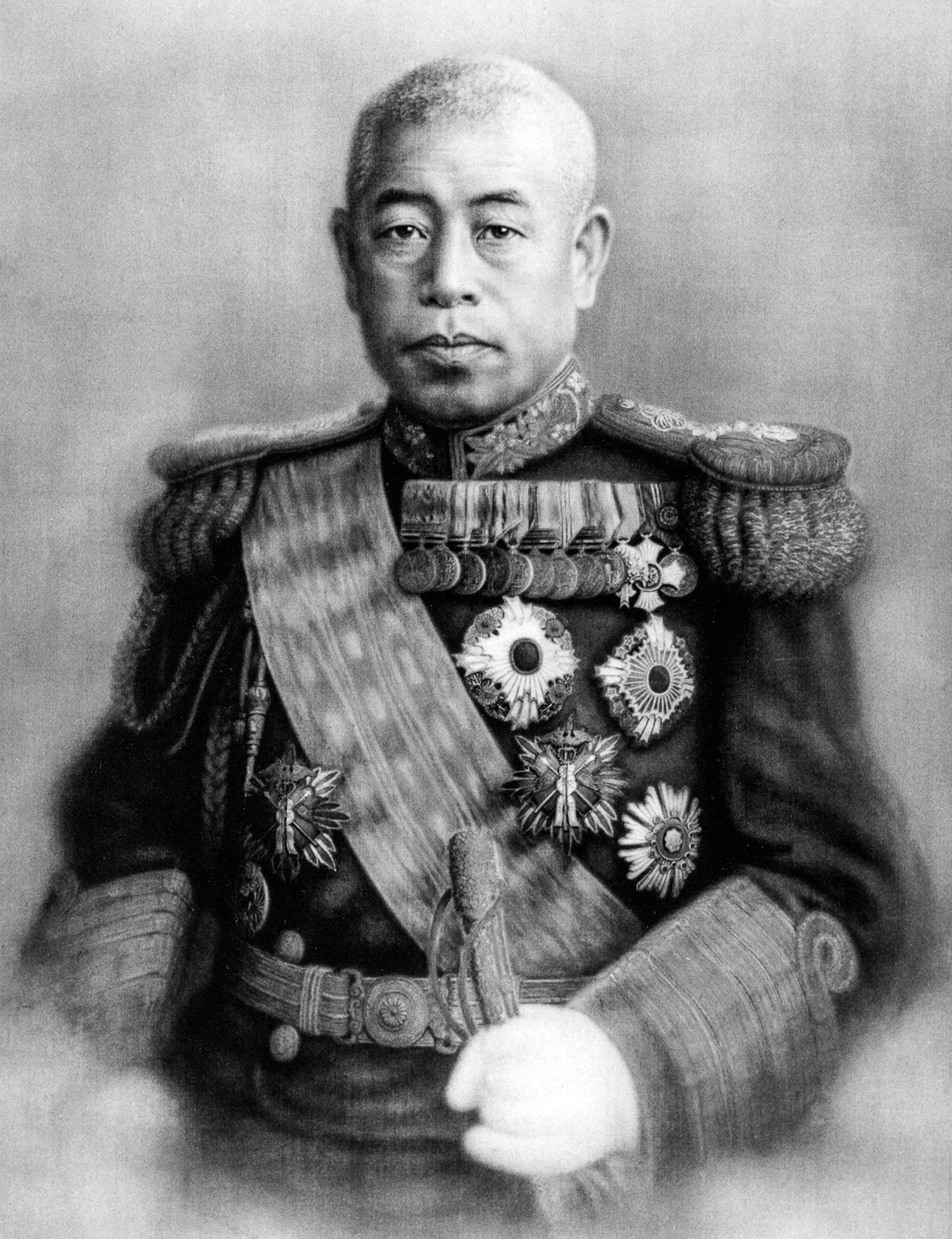 Formal wartime portrait of Admiral Isoroku Yamamoto, one of Japan’s most influential naval leaders during the Second World War. He appears in dress uniform with decorations, reflecting his senior rank and service. Yamamoto had studied in the United States earlier in life and understood the scale of American industry, yet still led Japan’s fleet into conflict. His planning of the Pearl Harbor attack made him a primary target for U.S. forces. Operation Vengeance in April 1943 specifically sought to eliminate him after his travel schedule was decrypted. His loss deprived Japan of its most skilled strategist and boosted American morale.