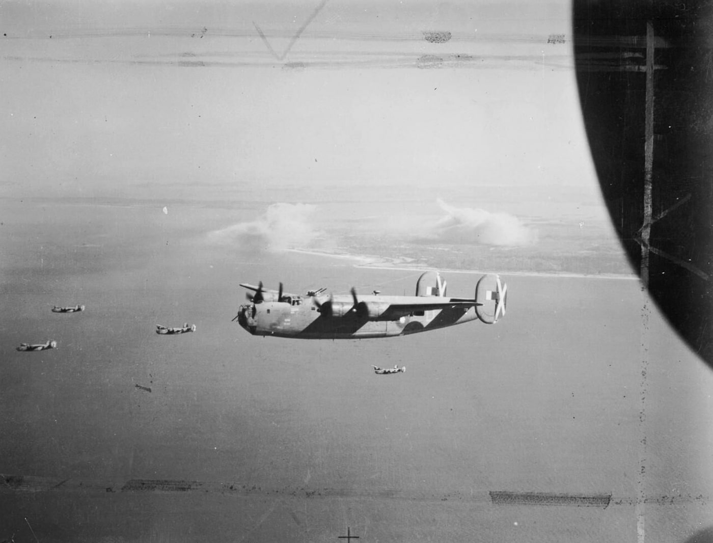 A formation of Consolidated Liberator B Mk VI bombers of the Royal Air Force No. 356 Squadron is photographed flying back to base at Salbani, India, on 21 January 1945. Below in the background lies Ramree Island, which had just been bombed to weaken Japanese defenses before Allied landings. The Liberators fly in tight formation, their long wings and twin tails silhouetted against the sky. These aircraft were adapted from the American B-24 and saw extensive RAF use in Southeast Asia. The bombing of Ramree was part of the campaign to secure control of Burma and surrounding islands. The image highlights the reach of RAF heavy bombers operating from India into Japanese-held territory. It captures both the geography of the campaign and the scale of the air effort.
