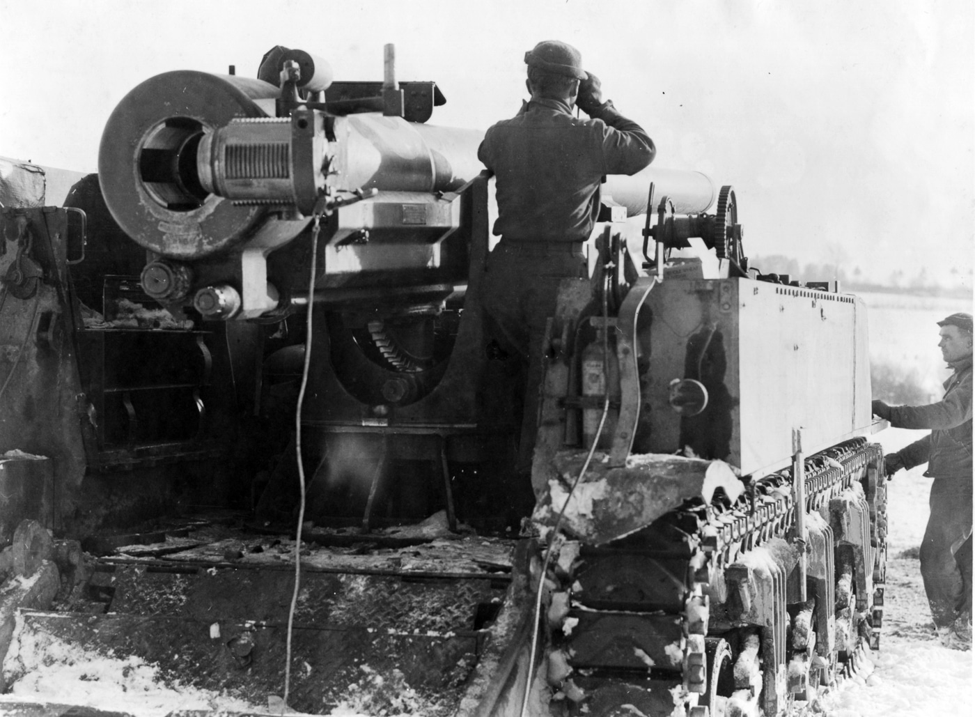 An M12 Gun Motor Carriage belonging to the 97th Field Artillery Battalion is pictured in France during January 1945. The vehicle mounts a 155mm M1918 gun on the chassis of an M3 tank, with the open-topped crew compartment visible behind the weapon. Snow and winter conditions surround the vehicle, reflecting the harsh environment of the campaign. The M12 was capable of firing a 95-pound shell at a velocity of over 2,400 feet per second, giving it the power to penetrate bunkers and strongpoints. Only ten rounds could be carried on the vehicle, making resupply by M30 cargo carriers essential. The unit used the gun in both direct and indirect fire roles depending on battlefield needs. This photograph documents the presence of one of America’s rarest self-propelled guns in the final winter of the war in Europe.