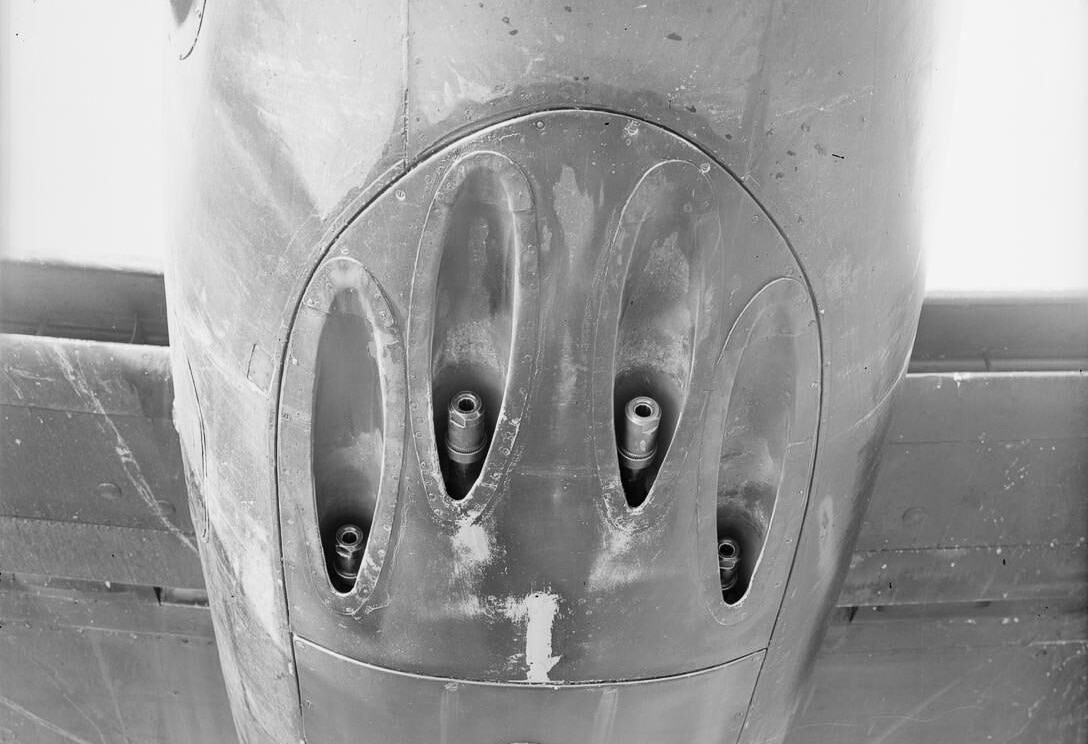 A de Havilland Mosquito NF Mk XIII night fighter displayed with its four 20mm Hispano cannons mounted in the nose section. The aircraft is painted in a typical dark night camouflage scheme, optimized for stealth during nocturnal operations. The Hispano cannons were standard RAF armament, offering high rate of fire and destructive power against both bombers and ground targets. The NF XIII was fitted with airborne radar, allowing pilots to intercept German aircraft during night raids. This version of the Mosquito combined speed, wooden construction, and heavy armament to create one of the most effective night fighters of World War II. The photograph highlights the placement of the cannons beneath the cockpit area. It captures the balance of firepower and aerodynamic efficiency that defined the aircraft.