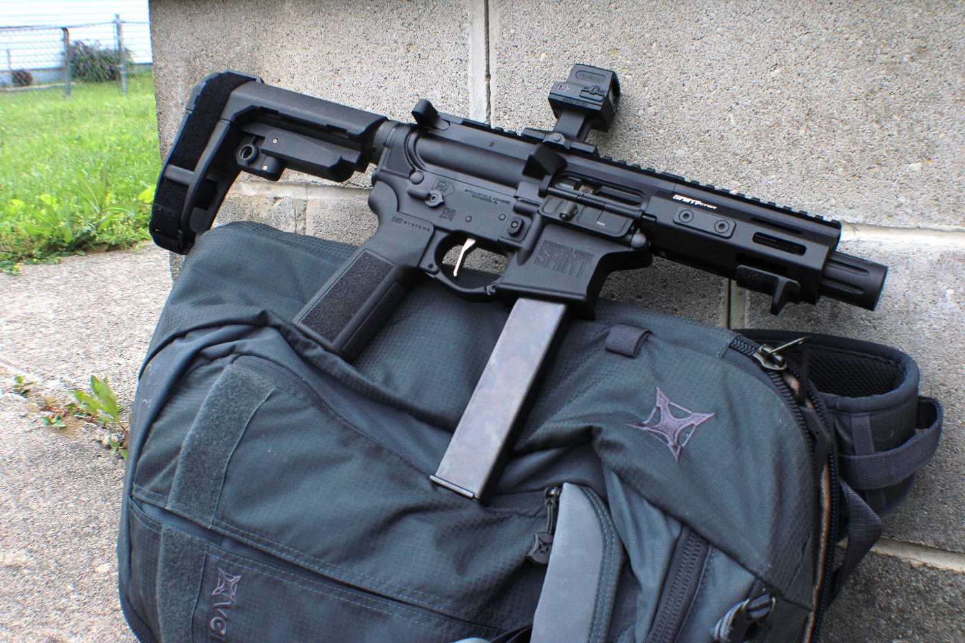 Image depicts a Springfield Armory SAINT Victor 9mm pistol with a 5.5-inch barrel staged for home defense use inside a house. The firearm is equipped with a red dot optic for rapid sight acquisition during close-quarters encounters. A collapsed pistol brace shortens overall length, making the 9mm carbine easy to maneuver through hallways, doorframes, and stairwells. The slim handguard and short profile reduce snag points on furniture or walls while maintaining balance and control under stress. This setup shows how the SAINT Victor 5.5” 9mm combines compact design with defensive firepower, ideal for protecting family members in confined spaces.