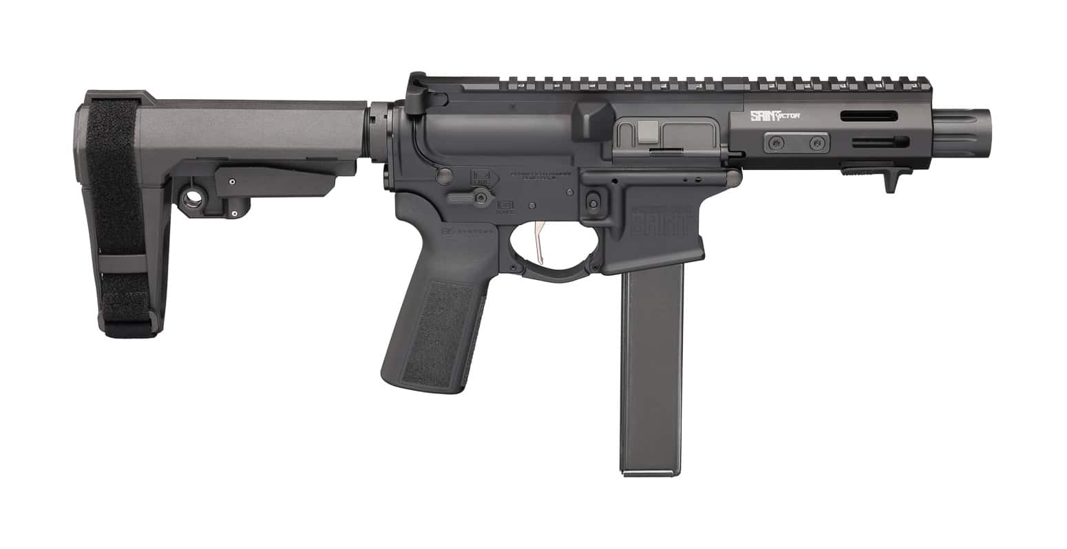 Image shows a Springfield Armory SAINT Victor 5.5” 9mm pistol-style carbine equipped with an arm brace and a small red dot optic, photographed against a neutral background. The collapsed brace and short 5.5-inch barrel are clearly visible, highlighting the compact AR profile designed for close-quarters and urban defense use. Controls and magazine well are shown for context, suggesting quick manipulation and reloads during stress. The red dot is mounted for fast sight acquisition at typical defensive distances, and the slim handguard minimizes snag points when moving through doorways or vehicles. This composition communicates suitability for home defense, CQB, and vehicle deployment where a full-length rifle would be impractical. Keywords included: SAINT Victor 5.5” 9mm, arm brace, compact AR, 9mm carbine, red dot, home defense.