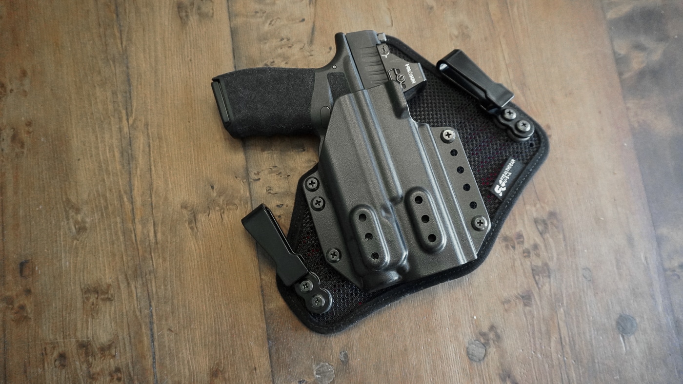 Photograph of a Springfield Armory Hellcat Pro pistol fitted into the StealthGearUSA Ventcore 2.0 IWB Mini holster. The compact 9mm pistol sits securely inside the molded Kydex shell, which is shaped for proper retention and smooth draw. The holster’s ventilated padded backing is visible against the inner side, designed for comfort against the body. Edges of the Kydex are rounded, reducing friction against clothing. The pistol appears with a clean fit, showing how well the holster is molded for this model. This setup represents a modern concealed carry configuration. The focus of the image is on fit and holster alignment.