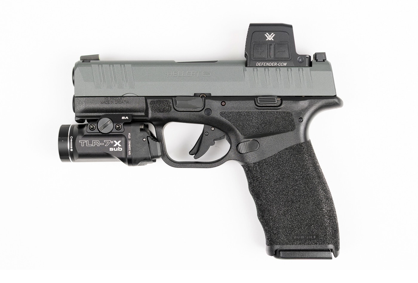 Side view of a Springfield Armory Hellcat Pro handgun with a Vortex Defender-CCW Enclosed red dot sight installed. The optic is mounted directly to the slide using the Shield RMS footprint, eliminating the need for an adapter plate. The compact CCW model is designed to keep weight and bulk to a minimum, making it well-suited for concealed carry. Its 7075 aluminum housing features Fast-Rack texturing at the front for slide manipulations, while the aspherical lens provides a clear, distortion-free sight picture. The optic’s solar panel and side-loading battery are visible, emphasizing its dual-power system. The pistol’s slim profile remains intact, even with the red dot attached.