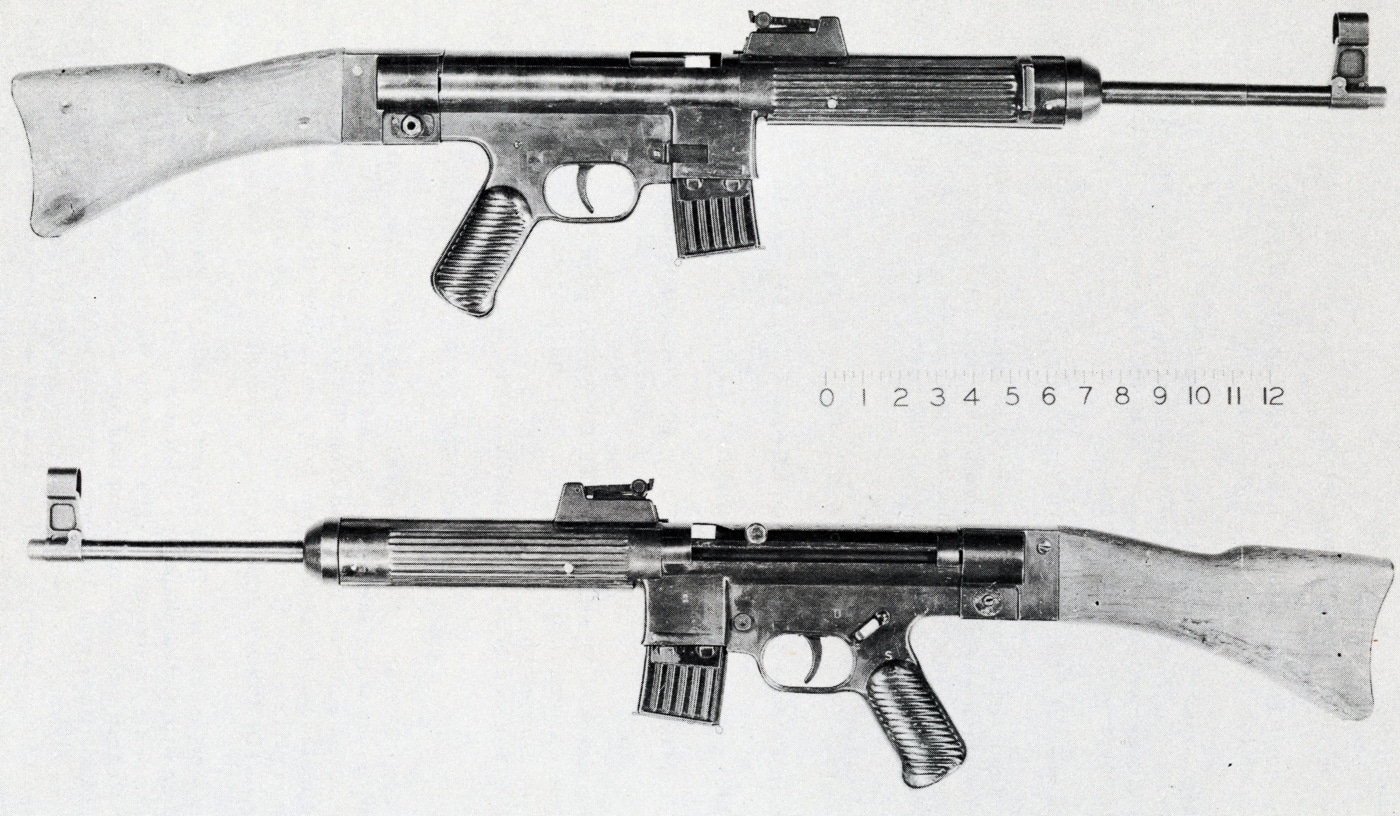 The image shows a German StG 45(M) assault rifle prototype chambered in 7.92x33mm Kurz. The rifle is fitted with a compact 10-round detachable magazine instead of the more common 30-round version used in the Sturmgewehr 44. Its stamped steel receiver and plain wooden stock emphasize the utilitarian, late-war German design. The inline stock and sights directly over the barrel highlight the rifle’s improved controllability and accuracy in automatic fire. This experimental weapon was never mass-produced, though parts for about 30 rifles were completed. The 10-round magazine was reportedly used by Mauser engineers for convenience during testing. The StG 45(M) later became the foundation for postwar roller-delayed rifles such as the CETME and HK G3.