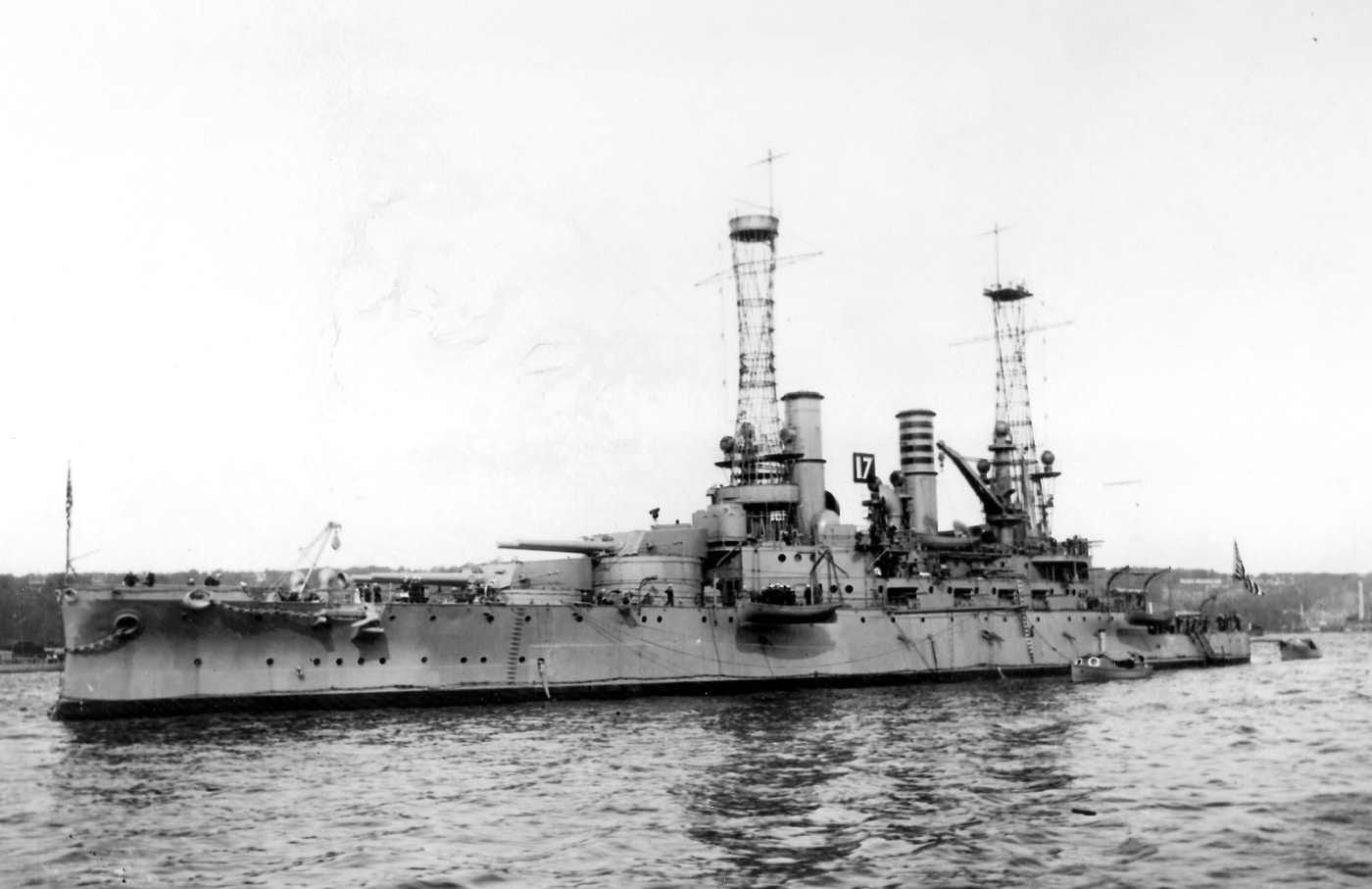 The photograph shows USS Michigan (BB-27), one of the first U.S. Navy dreadnought-style battleships, anchored in New York Harbor in 1912. The ship has a long steel hull, tall cage masts, and multiple large-caliber gun turrets in fore-and-aft arrangement. Unlike earlier pre-dreadnoughts, Michigan carried a uniform heavy gun battery, following the design principles pioneered by Britain’s HMS Dreadnought. Her presence in New York Harbor reflected the United States’ growing naval ambitions and modernization of its battle fleet. Michigan was a South Carolina–class battleship, built to demonstrate that the U.S. could keep pace with European powers in naval technology. The photo captures her imposing silhouette against the city backdrop, symbolizing a new era of American sea power.