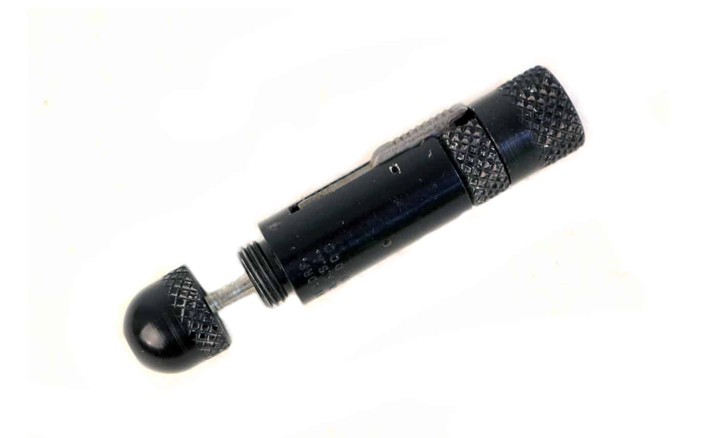 The photo shows the process of charging a MAC Stinger pistol, a compact tubular firearm from the 1970s. The user inserts a single .22 caliber rimfire round into the short smoothbore barrel. The barrel is then threaded into the body of the gun to prepare it for firing. Unlike conventional pistols, the Stinger has no magazine, slide, or grip, making loading more awkward and hazardous. A wire safety pin could be inserted to prevent accidental discharge, though many examples are missing this safety feature. Once charged, the weapon was immediately live and ready to fire, which made it extremely unsafe to handle casually. This unusual loading method underscores why the MAC Stinger is considered impractical despite its concealability.