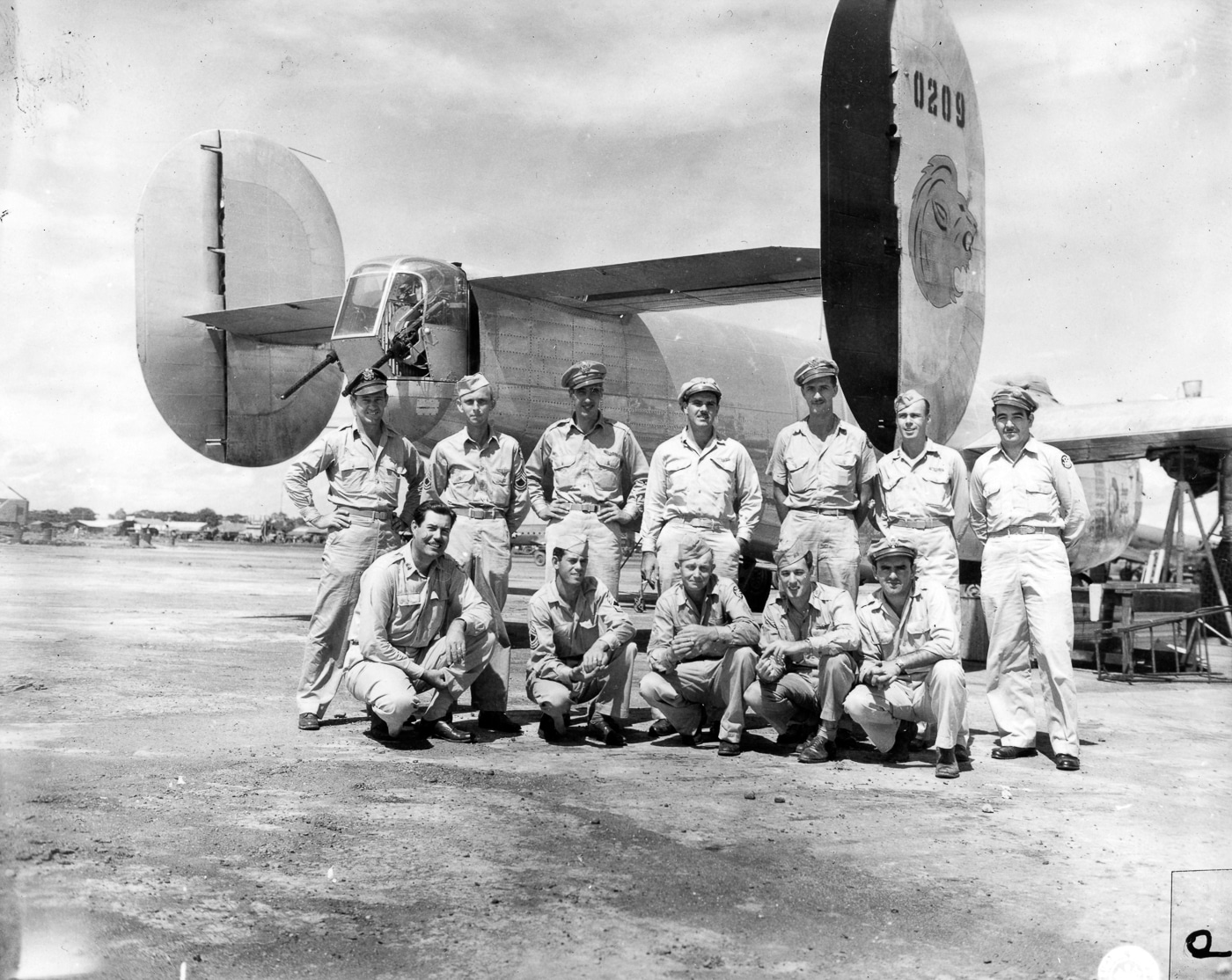 A group of U.S. Army Air Forces personnel from the 5th Air Force pose for a photograph in front of their Consolidated B-24 Liberator during World War II. The airmen are dressed in flight gear, including leather jackets, flight suits, and parachute harnesses, reflecting preparation for combat missions. The bomber’s nose and fuselage form the backdrop, its size emphasizing the scale of the aircraft compared to the men who flew it. Each crew typically consisted of ten men, including pilot, copilot, navigator, bombardier, gunners, and radio operator. In the Pacific Theater, crews like this flew long missions over water, often facing harsh weather and enemy fighters. The photo captures both camaraderie and the seriousness of their work. It provides a human dimension to the Liberator’s combat history.