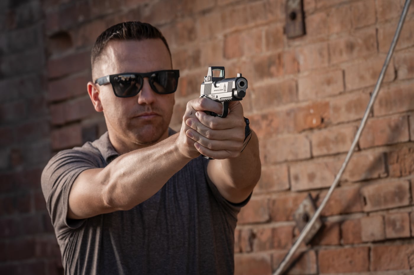 The photo shows a man aiming a Springfield Armory pistol in a defensive stance during an EDC self-defense situation. His posture suggests readiness to respond to an immediate threat. This image represents the tactical stage of self-defense, where a firearm may need to be used as the last resort. The article highlights that carrying a weapon means accepting full responsibility for personal safety. The discussion also emphasizes that awareness and preparation can help avoid reaching this point whenever possible. Still, if forced, the carrier must be trained to act with control and precision. The picture reinforces the seriousness of everyday carry and its connection to situational awareness.