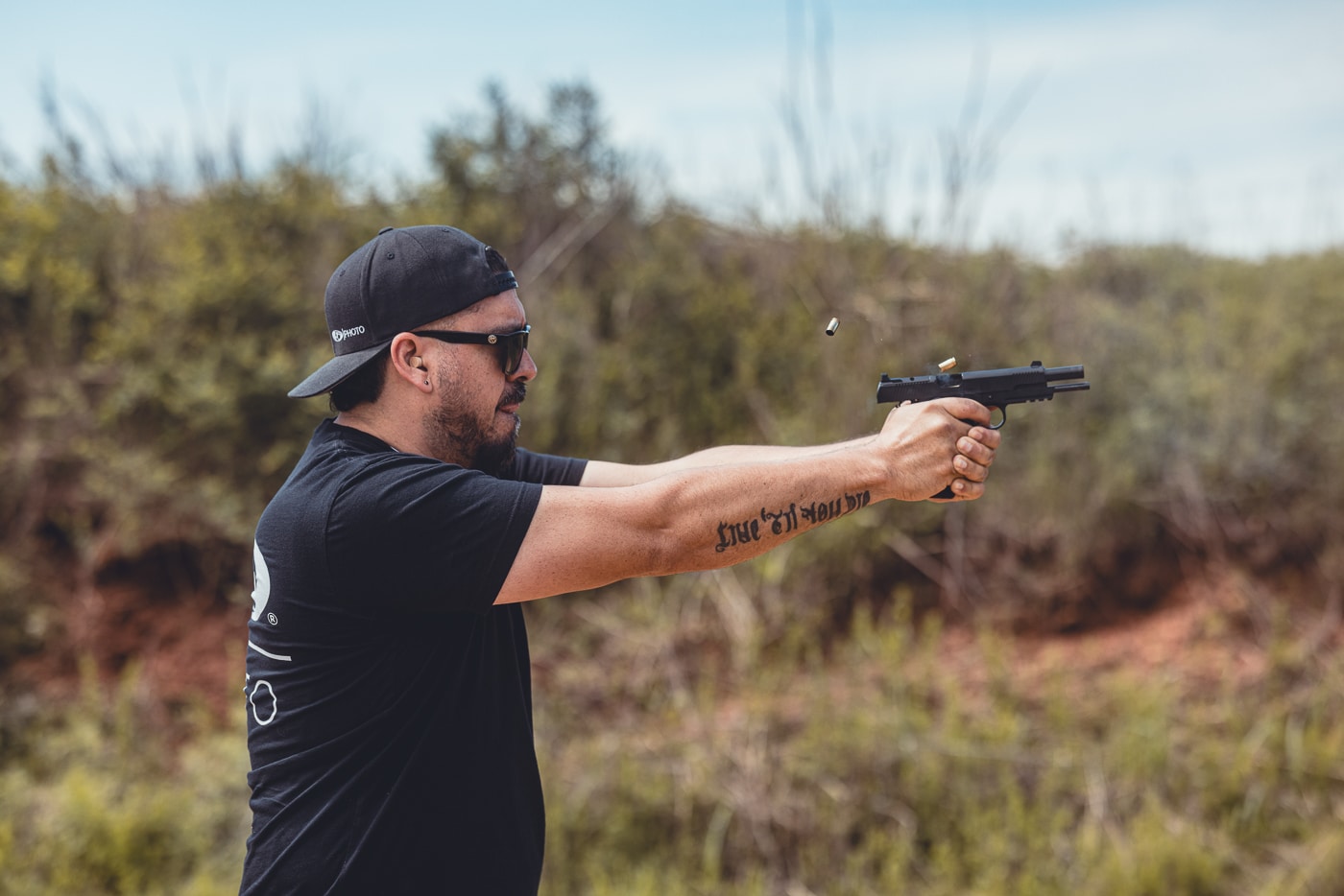 The image shows a shooter conducting rapid fire drills with a Springfield 1911 TRP AOS using its iron sights. The handgun is cycling through live rounds, with the slide partially retracted in the firing sequence. The pistol’s profile, forward serrations, and G10 grips are visible, reinforcing its premium build. The use of traditional iron sights instead of a red dot demonstrates the pistol’s versatility for different training styles. The shooter maintains a two-handed stance, illustrating control and accuracy even under speed. The photo highlights how the TRP AOS continues the 1911 legacy while delivering modern performance.