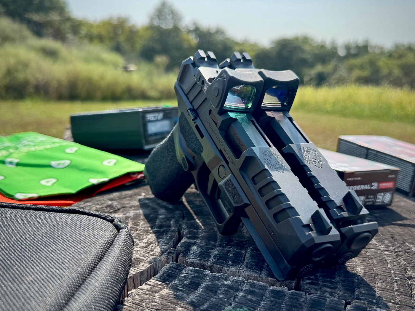 Two Springfield Armory Echelon pistols are pictured side by side, each mounted with a Trijicon RMR reflex sight. One optic features the traditional red reticle, while the other uses the new green LED dot. The comparison highlights the difference between red and green aiming points, showing how the human eye may pick up the green dot more quickly. Both optics retain the patented protective ears, forged aluminum housing, and low-profile fit on the Echelon slide. The pistols’ serrations and optics mounting cuts are visible, emphasizing the clean integration of the sights. This setup demonstrates the choice available for shooters seeking either red or green dot performance.