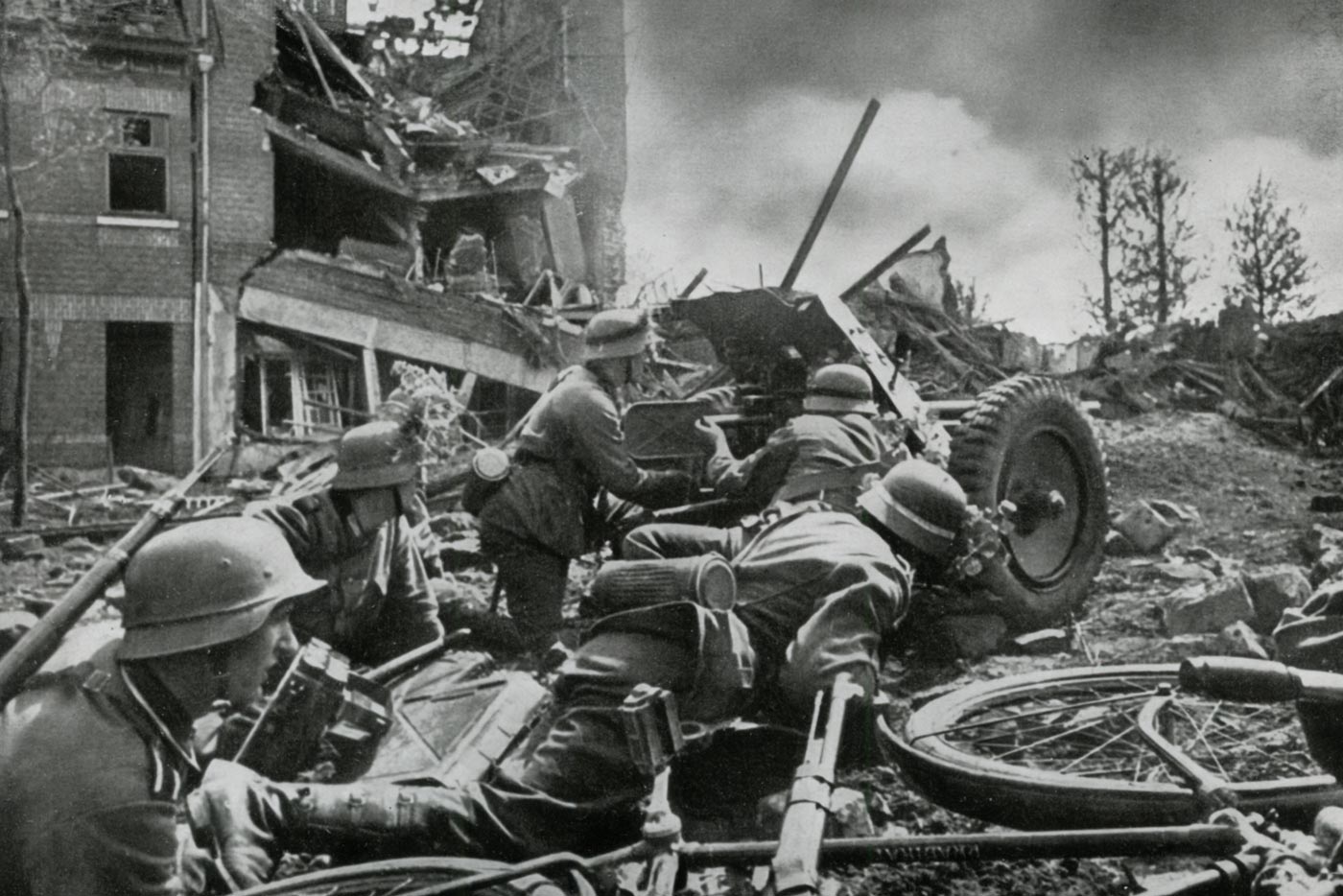 German soldiers operate a 3.7 cm Pak 36 anti-tank gun during fighting in France in 1940. The crew crouches around the weapon as it fires, producing smoke and recoil. The Pak 36 was a lightweight, towed anti-tank gun designed for mobility and rapid deployment. At this stage of the war, it could penetrate most Allied light tanks and armored cars. Its effectiveness diminished as soon as heavier tanks appeared, but in France it contributed to the rapid German advance. The photo captures the weapon in active use, illustrating how it functioned in combat conditions.