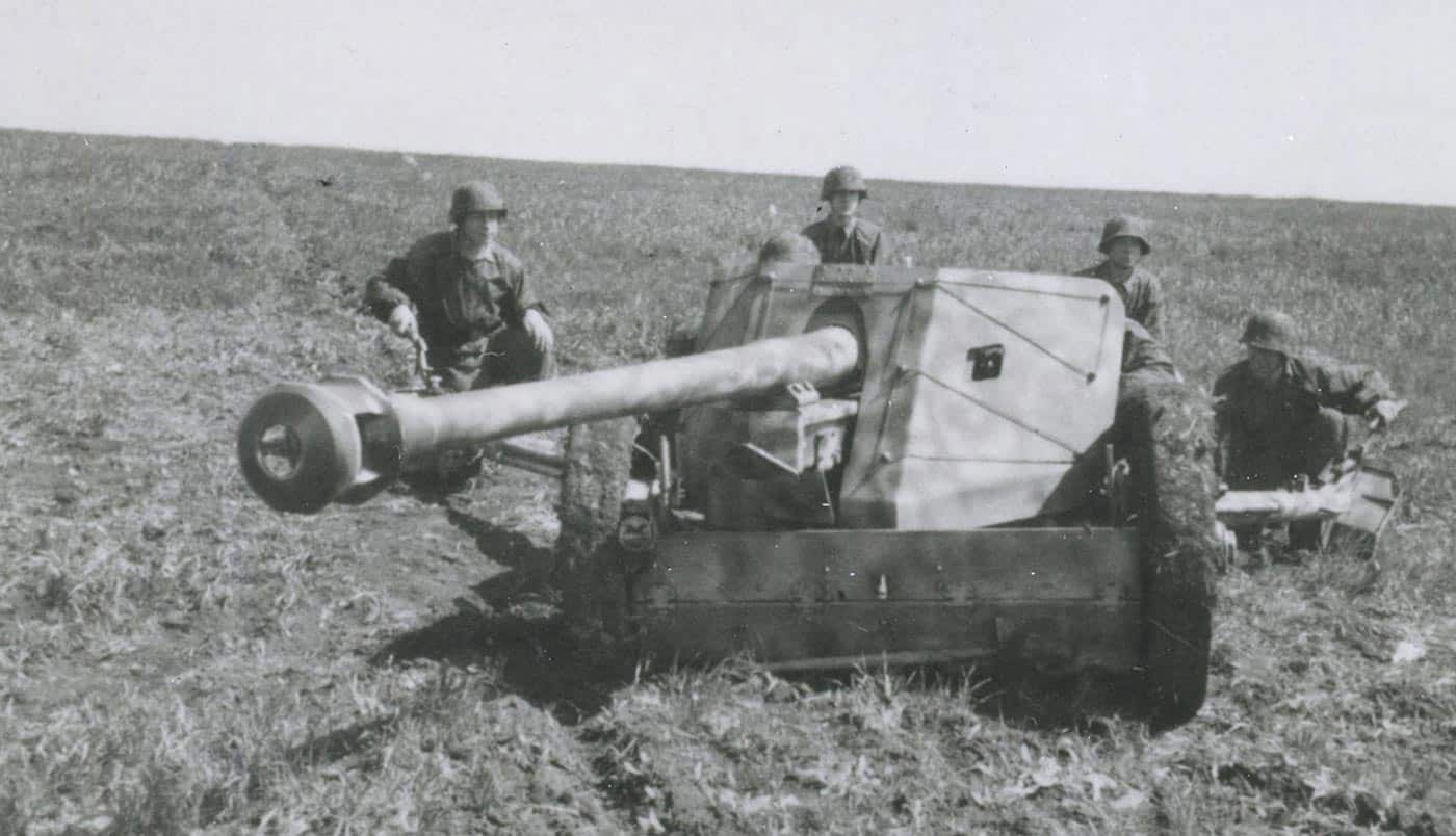 A group of German soldiers prepares to fire a 7.5 cm Pak 40 anti-tank gun at a Red Army tank on the Eastern Front. The gun crew positions themselves behind sandbags and earthworks as they aim at the incoming target. The Pak 40, introduced in 1942, was capable of penetrating the armor of Soviet T-34s at over a thousand meters. The soldiers work quickly under pressure, highlighting the urgency of tank battles on this front. Despite its effectiveness, the Pak 40’s heavy weight made it difficult to reposition once set up. This image captures both the technical power of the gun and the human effort required to operate it.