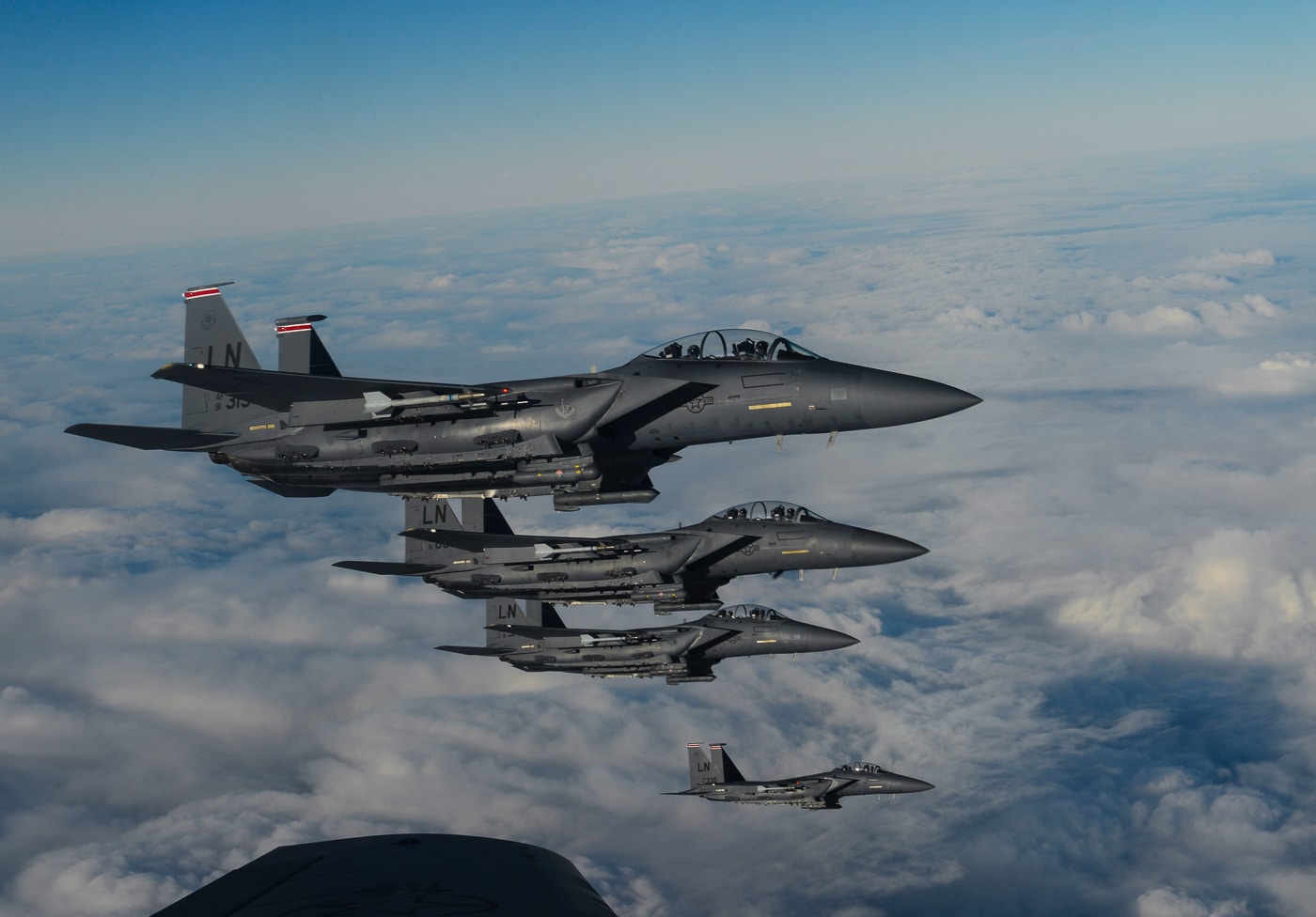 Two U.S. Air Force F-15D Eagle aircraft from the 48th Fighter Wing, RAF Lakenheath, England, fly in formation off the wing of a KC-135 Stratotanker assigned to the 349th Air Mobility Wing from Beale Air Force Base, California. The photo, taken on December 2, 2016, shows the aircraft flying over the Atlantic Ocean under clear blue skies. The F-15Ds are twin-seat fighters used for both combat missions and pilot training. The KC-135 provides in-flight refueling support, extending the range and endurance of the fighters during long-distance missions. The aircraft maintain tight, precise formation as part of a routine transatlantic training operation. This image highlights the coordination, skill, and global reach of U.S. Air Force aircrews. It also emphasizes the importance of aerial refueling in maintaining continuous worldwide air operations.