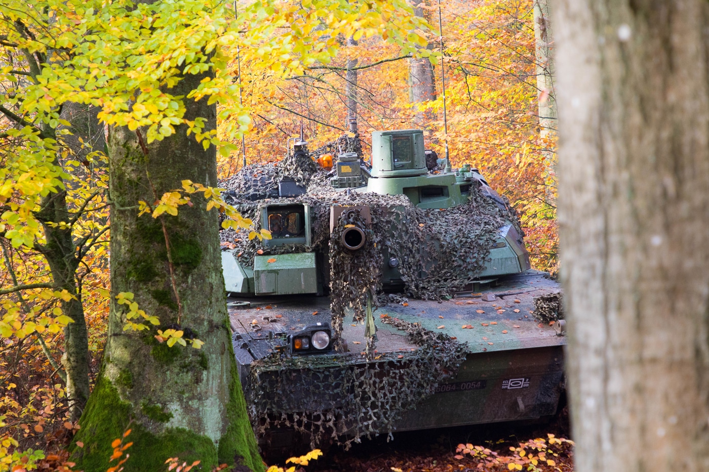 The image shows a French Leclerc tank positioned in a stationary defensive posture during Dragoon Ready 20 at the NATO Joint Multinational Readiness Center. The tank is camouflaged and waiting for simulated enemy forces to advance. Its long 120mm smoothbore gun is aimed forward, ready for engagement. The exercise replicates real battlefield conditions, with the crew maintaining vigilance from inside the vehicle. Dragoon Ready 20 was a multinational NATO event designed to test coordination, readiness, and joint response strategies. The scene highlights the Leclerc’s role as France’s main battle tank in combined exercises with allies.