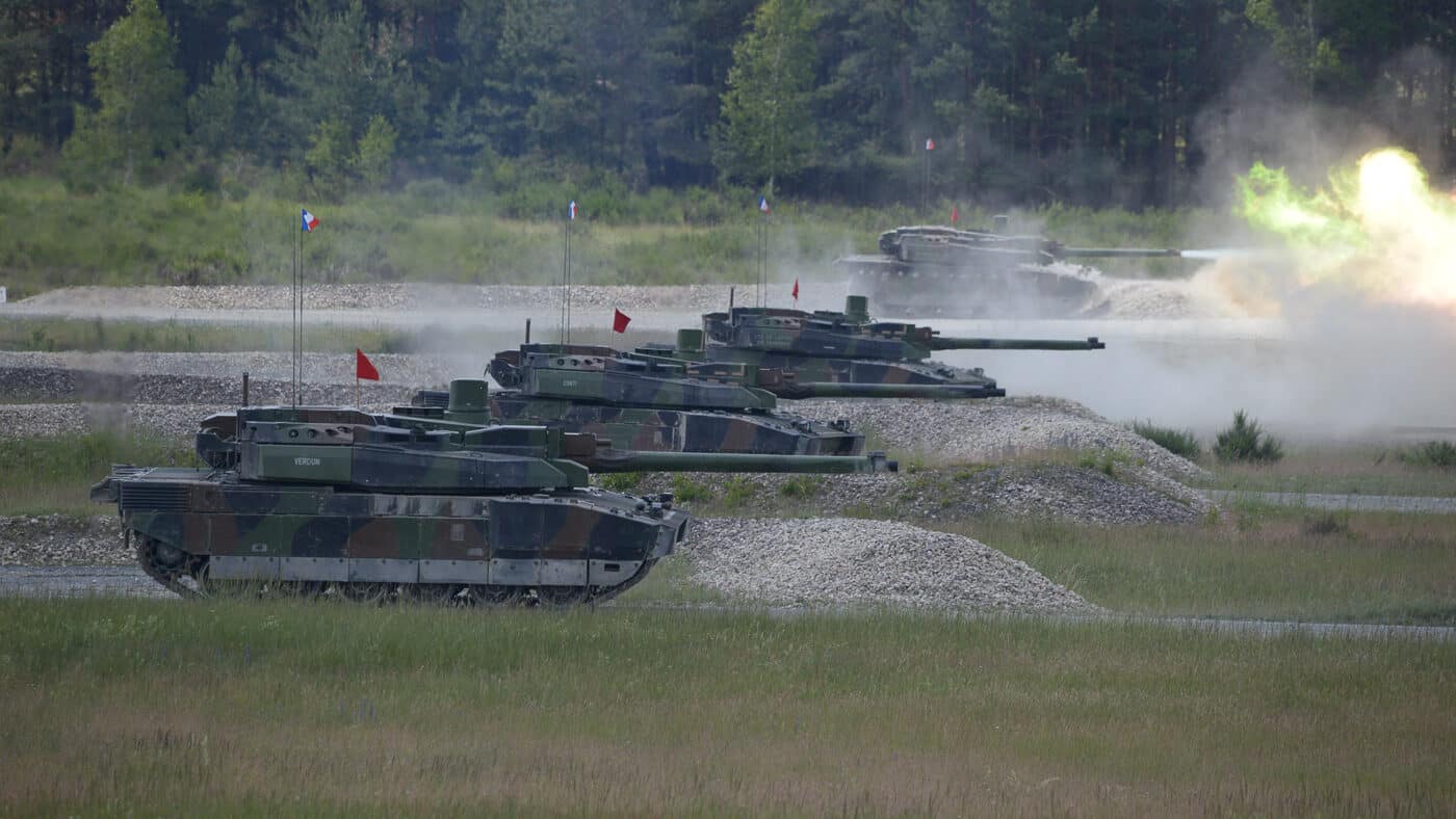 French Leclerc main battle tanks are pictured firing their primary weapons at the Grafenwöhr range in Germany. Multiple tanks engage designated targets at the same time, creating a display of coordinated live-fire maneuvers. The training ground is dusty and open, ideal for armored exercises. Each Leclerc is equipped with modular composite armor and its signature low-profile turret. Exercises like these reinforce NATO standards for interoperability and fire discipline. The image underscores the French Army’s commitment to maintaining proficiency in armored warfare alongside allied forces.