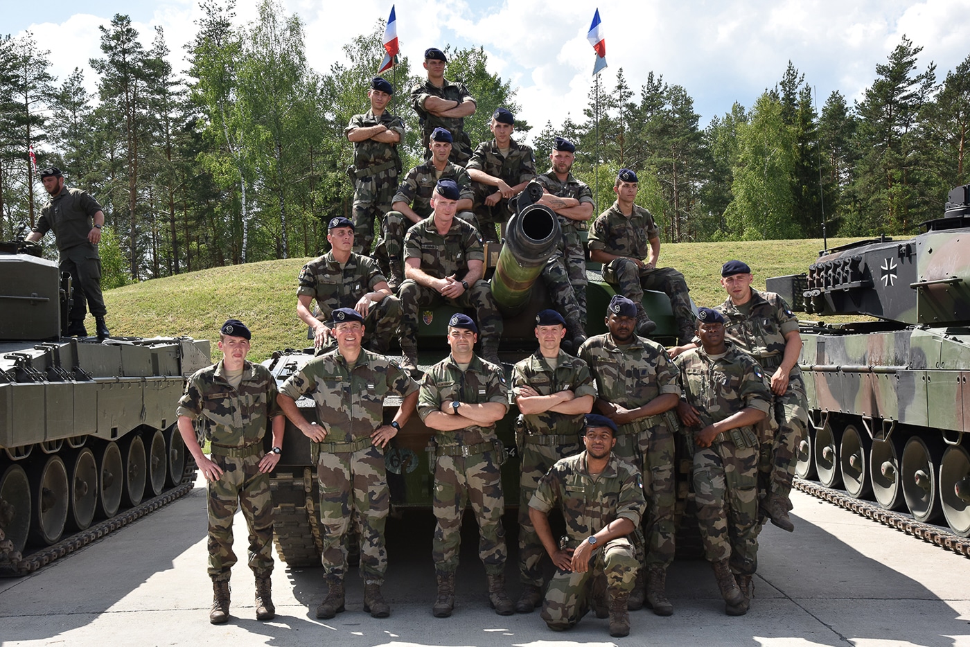 The image shows French tank crews from the 1er Régiment de Chasseurs posing together for a group photograph during training exercises. The soldiers are dressed in military uniforms, with some wearing helmets or gear, and they stand in front of or near their Leclerc tanks. The scene reflects camaraderie and unit pride, highlighting the teamwork essential in armored warfare. The 1er Régiment de Chasseurs is one of the French Army’s primary armored regiments and has long operated the Leclerc main battle tank. Training exercises like these prepare the unit for NATO deployments and national defense missions. The photo emphasizes the people behind the armored vehicles, showing their cohesion as a fighting force.