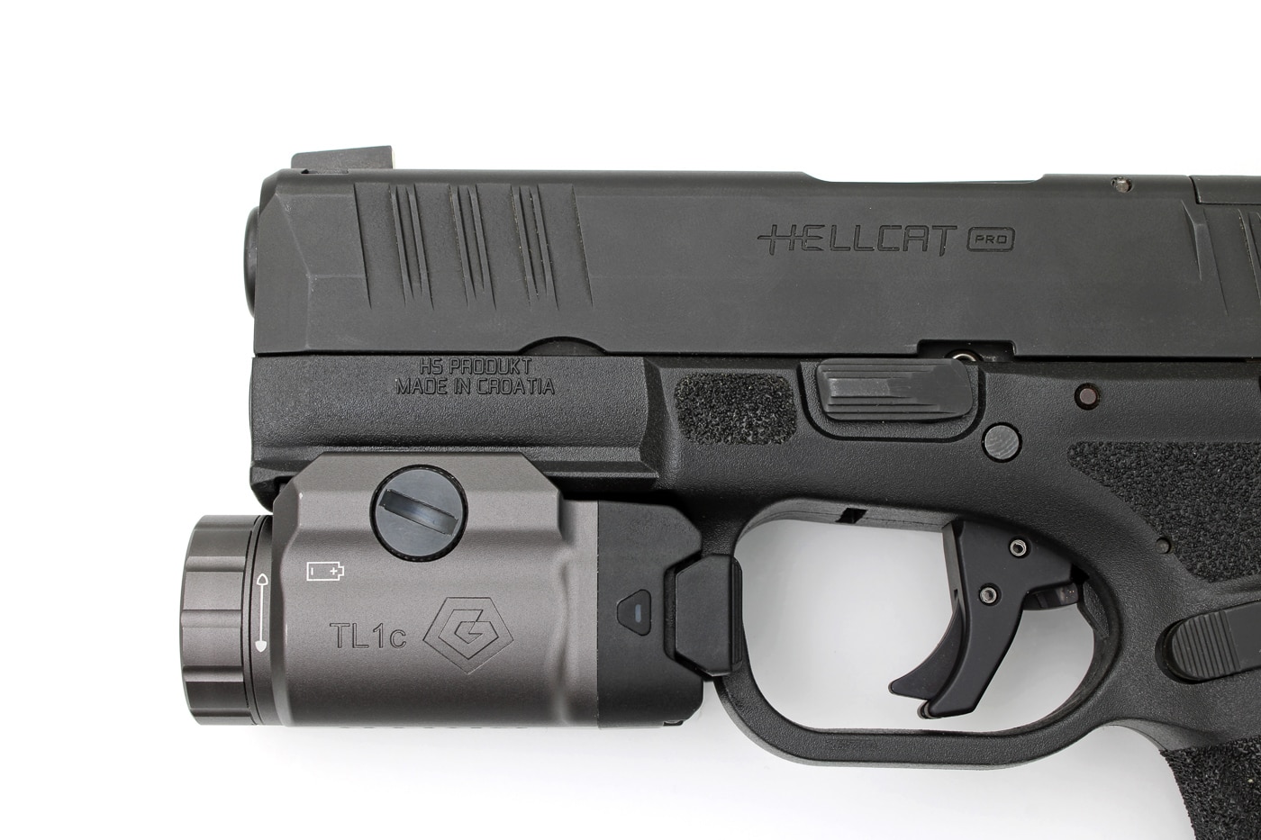 Photo of the GRITR TL1c Compact Weapon Light attached to the accessory rail of a Springfield Armory Hellcat pistol. The light fits securely beneath the barrel, with controls easily accessible for quick activation. The image demonstrates proper alignment, showing that the TL1c integrates well with the Hellcat’s compact frame without overhang or interference with holstering. Both the light and pistol are positioned to show their relative proportions and how the accessory complements the firearm’s design. The review mentions this as an example of the TL1c’s broad compatibility with defensive handguns.