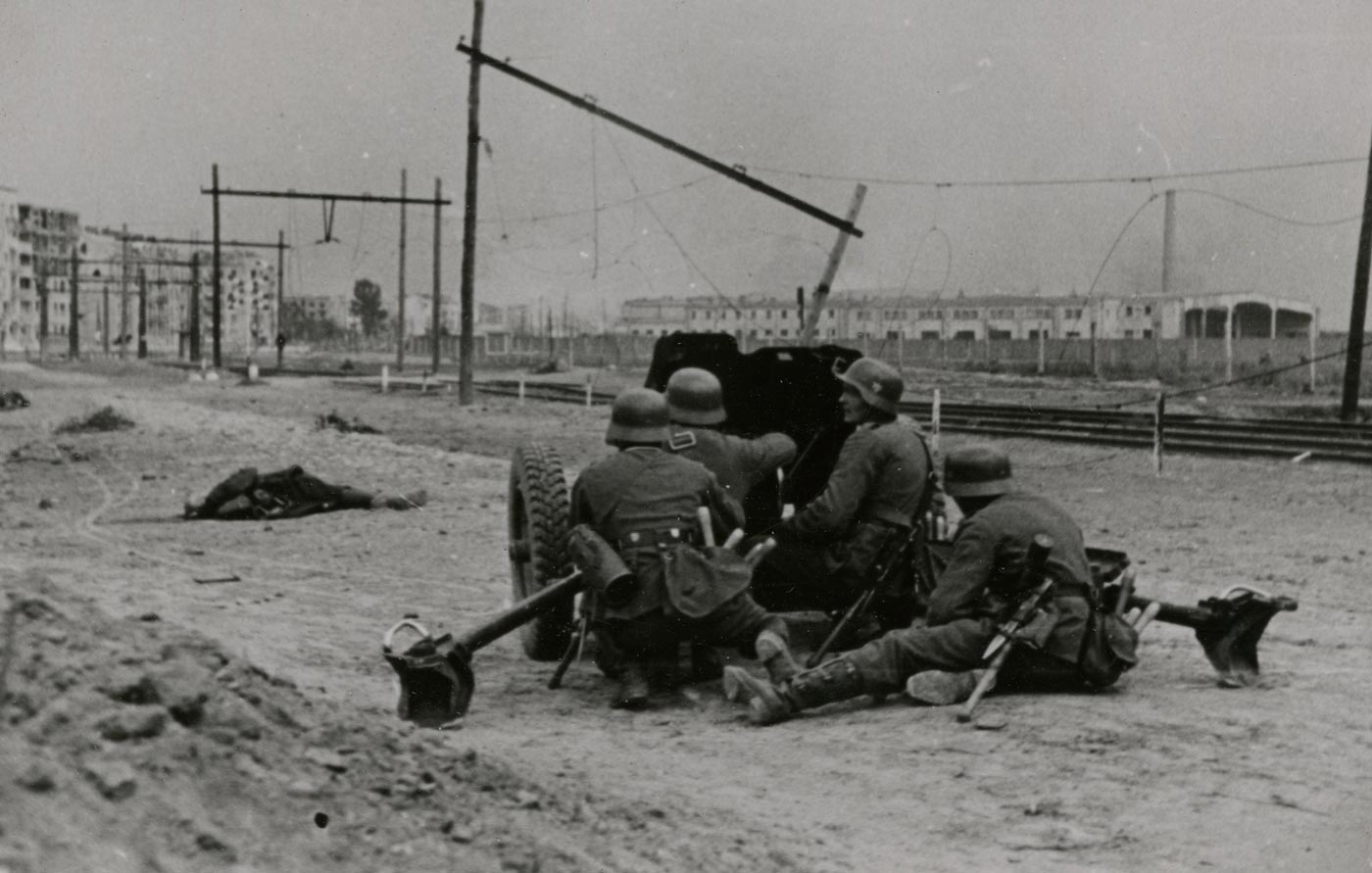 German troops are shown manning a 3.7 cm Pak 36 anti-tank gun set up on a bridge during World War II. The small-caliber weapon was Germany’s standard anti-tank gun at the start of the conflict. It was light, portable, and could be moved easily by its crew, making it suitable for defensive positions like this bridge crossing. However, its 37 mm rounds quickly proved ineffective against newer Allied tanks with thicker armor. In this photo, the crew members position the weapon carefully to cover the approach. The scene highlights how early-war equipment continued to be used despite its declining effectiveness.