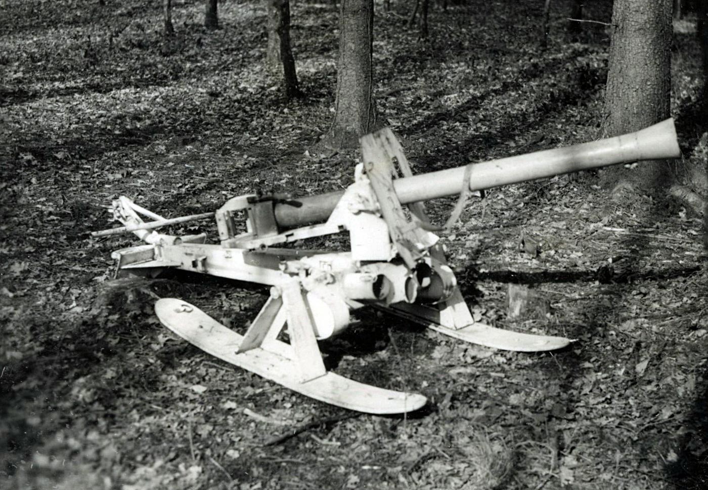 A German Raketenwerfer 43 Puppchen anti-tank weapon is photographed in a wooded area, mounted on skis for winter mobility. The Puppchen was a rocket launcher that fired the same 88 mm rocket as the Panzerschreck but used a breech-loaded system. Its carriage and wheels made it stable and accurate but also heavy and difficult to transport. By fitting skis, German troops adapted the weapon for snowy terrain on the Eastern Front. This improvisation reflects how anti-tank weapons had to be modified for different battlefield environments. The photo highlights the unusual appearance of the Puppchen compared to more common handheld launchers.