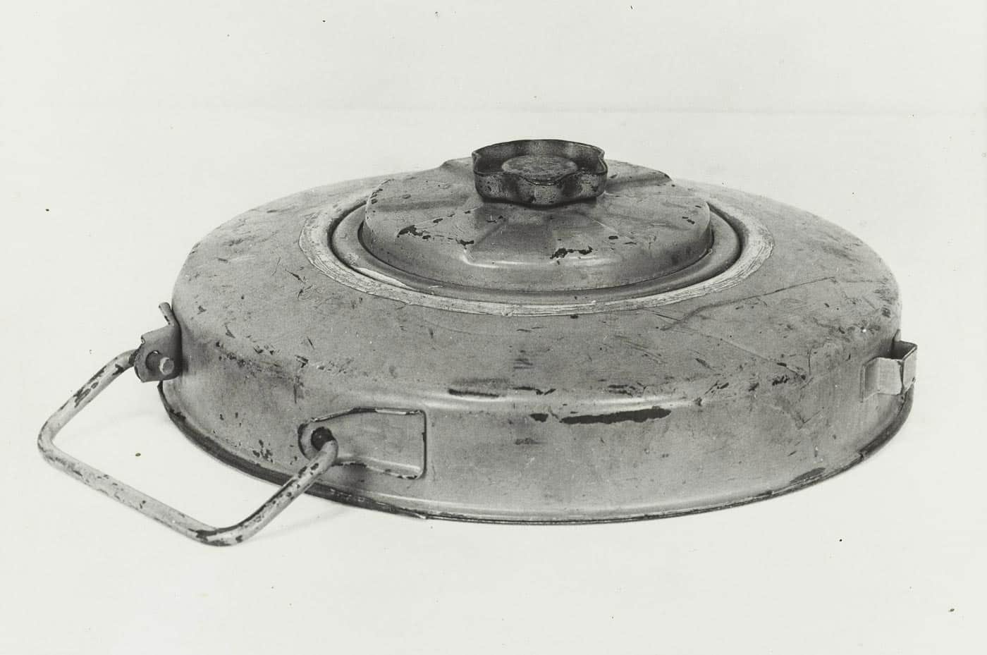 A German Tellermine 42 anti-tank mine is shown in this World War II photograph. The device is round and flat, designed to be buried just beneath the surface of a road or field. It contained a large explosive charge capable of blowing off tank tracks or destroying light armored vehicles. When sufficient weight was applied, usually from a tank passing overhead, the mine detonated. The Tellermine 42 was an evolution of the earlier Tellermine 35, improving reliability and ease of production. This image highlights the simple yet deadly design that made it one of Germany’s most common anti-tank defenses.